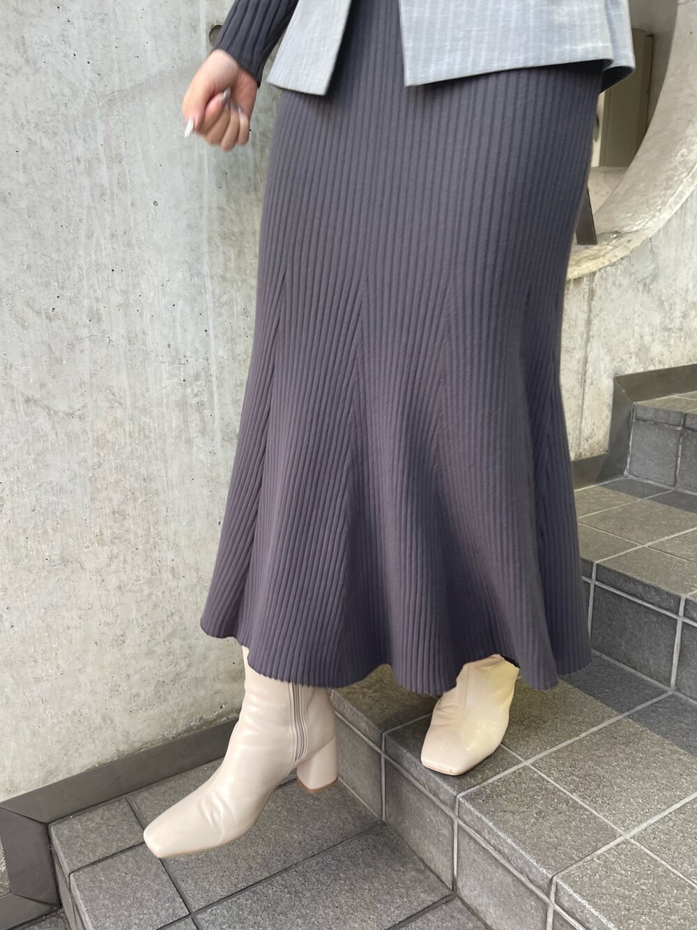 グレー系のワンピース、ホワイト系のブーツを着用したレディースの冬コーディネートの7枚目の写真