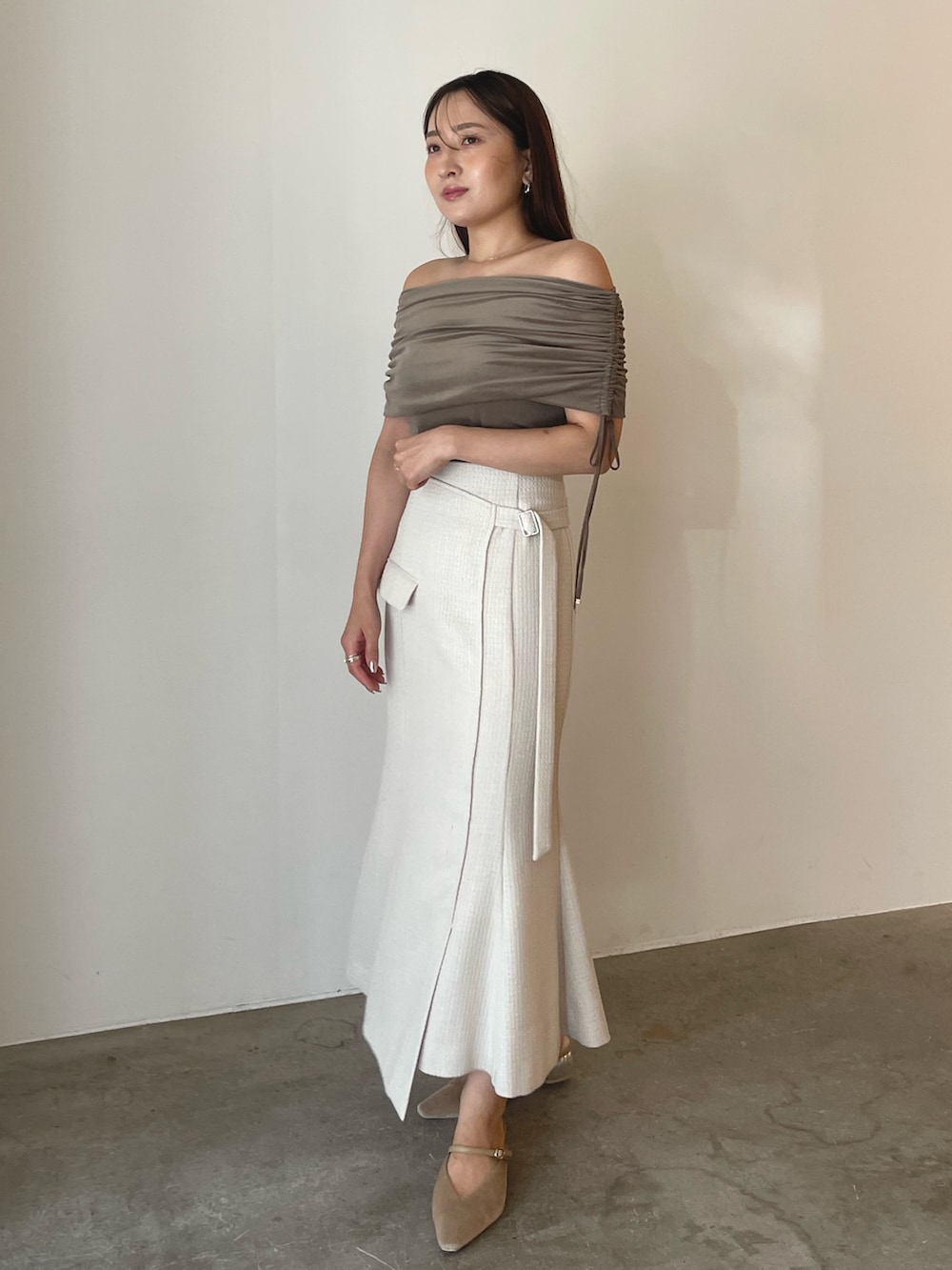 ベージュ系のパンプス、ブラウン系のTシャツ/カットソー、ホワイト系のスカートを着用したレディースの夏コーディネートの3枚目の写真