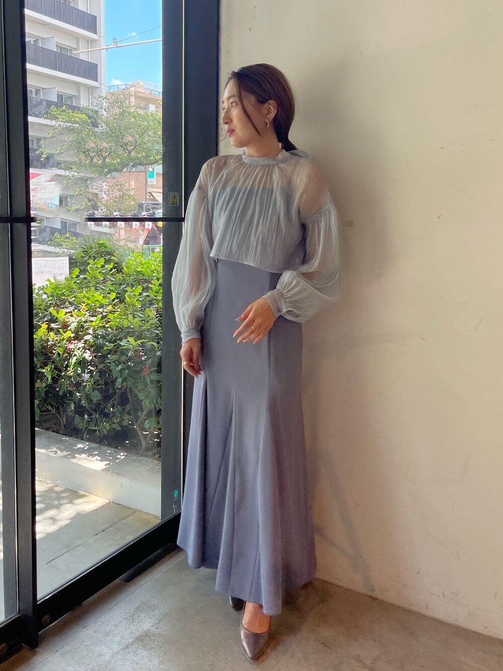 シルバー系のパンプス、ブルー系のドレスを着用したレディースの秋コーディネートの7枚目の写真