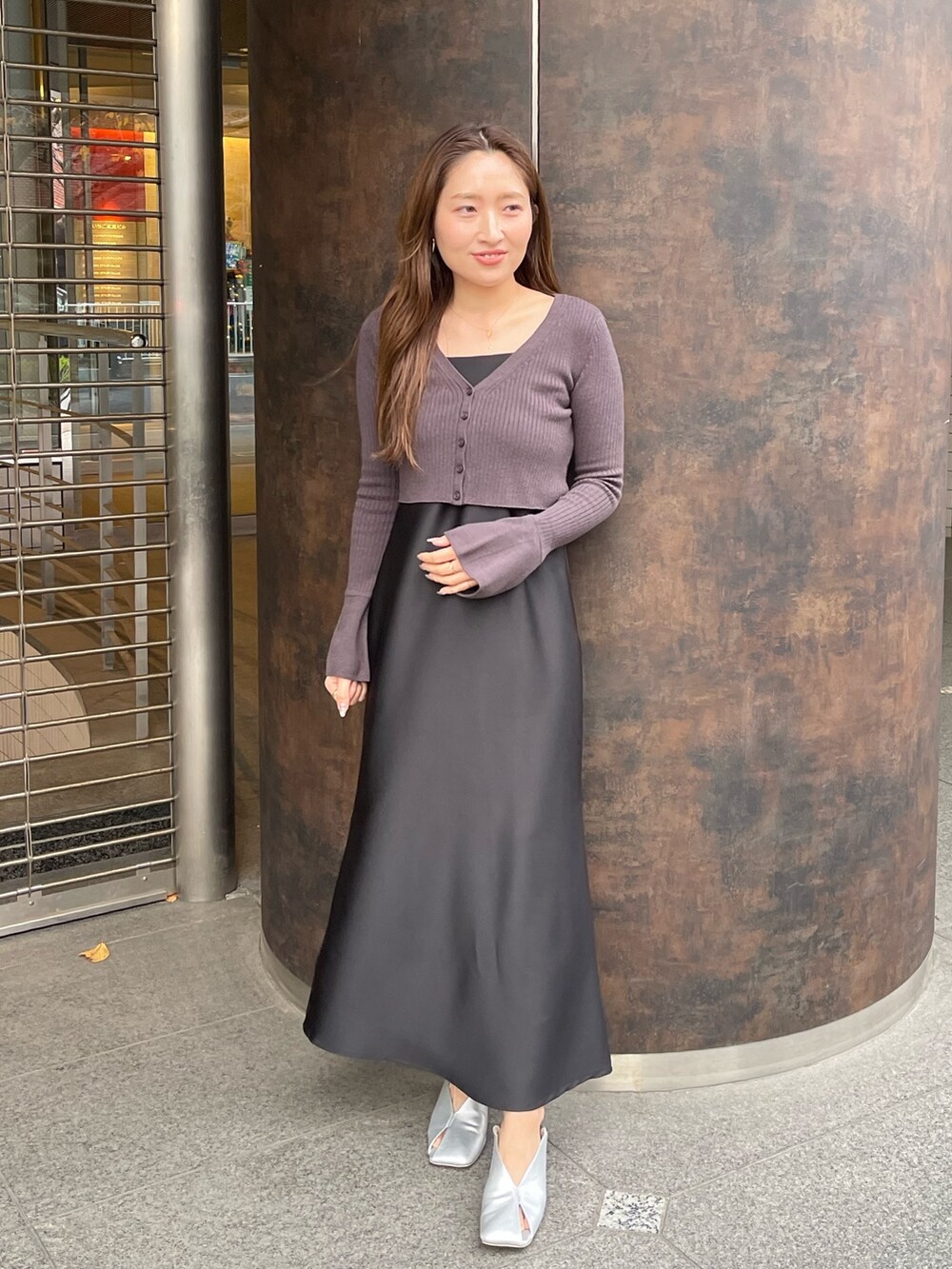 ブラック系のワンピース、シルバー系のパンプスを着用したレディースの冬コーディネートの2枚目の写真