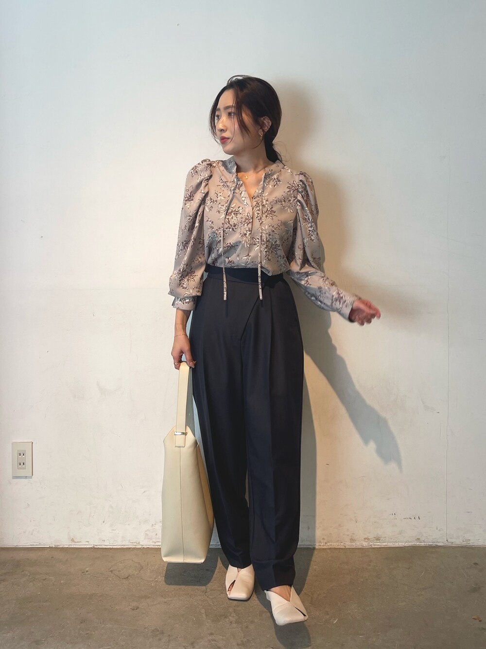 ホワイト系のショルダーバッグ、ホワイト系のパンプス、グレー系のシャツ/ブラウスを着用したレディースの冬コーディネートの3枚目の写真