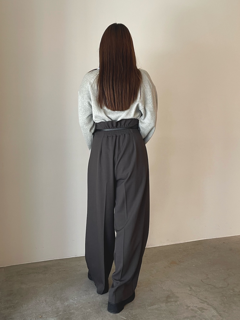 グレー系のニット/セーター、グレー系のその他パンツ、ゴールド系のピアス(両耳用)を着用したレディースの夏コーディネートの7枚目の写真