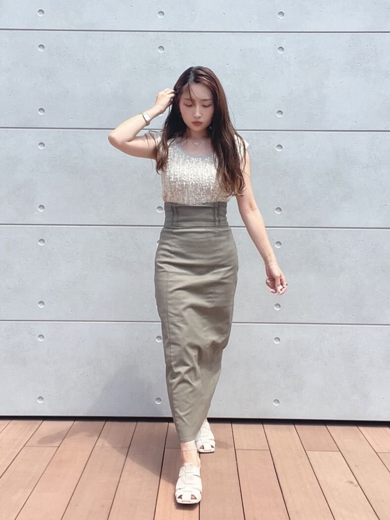 グレー系のスカート、ホワイト系のサンダル、ホワイト系のニット/セーターを着用したレディースの夏コーディネートの3枚目の写真