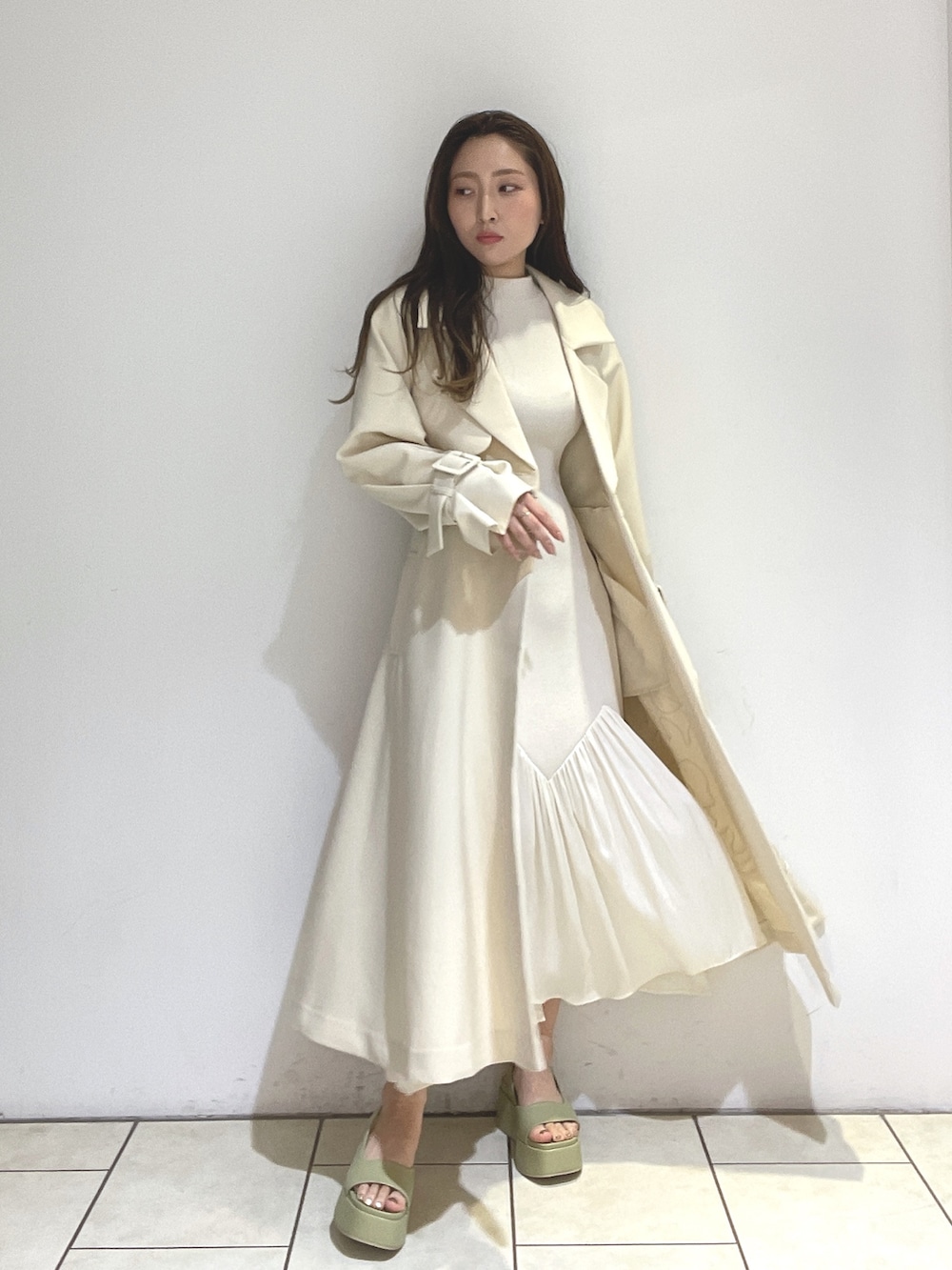 ホワイト系のトレンチコート、ベージュ系のサンダル、グリーン系のショルダーバッグを着用したレディースの冬コーディネートの8枚目の写真