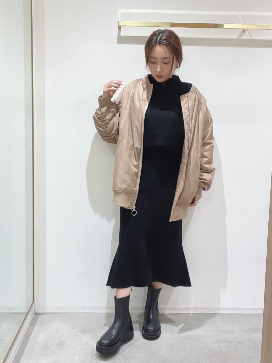 ブラック系のブーツ、ブラック系のニット/セーター、ブラック系のスカートを着用したレディースの秋コーディネートの4枚目の写真