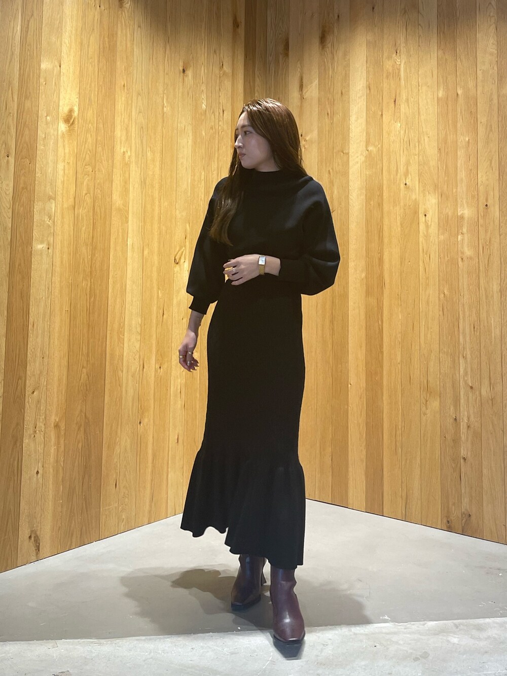 ブラウン系のブルゾン、レッド系のブーツ、ブラック系のワンピースを着用したレディースの秋コーディネートの6枚目の写真