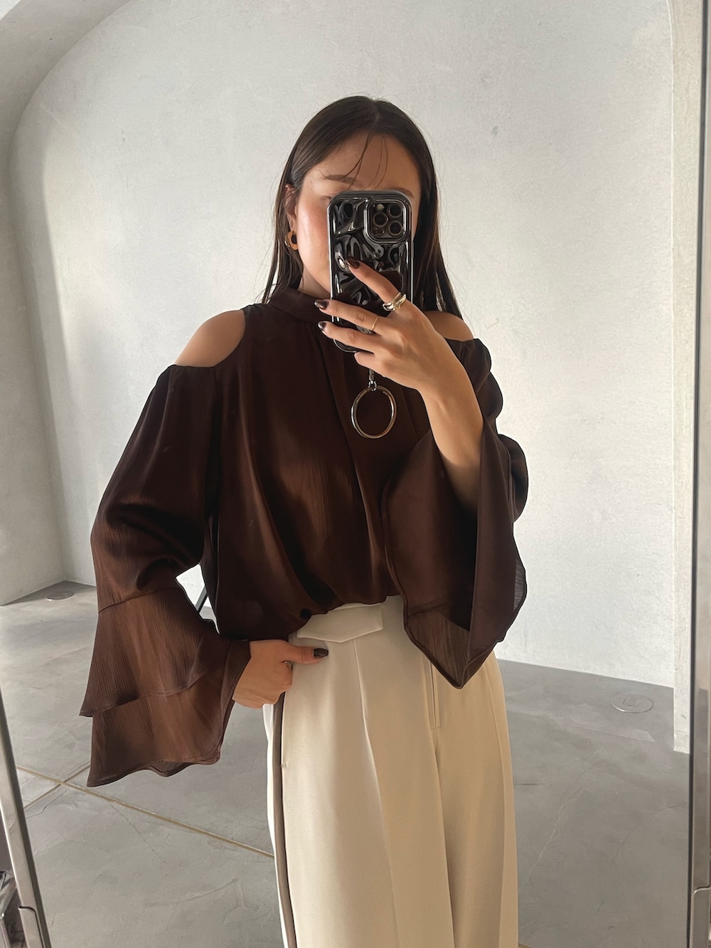 ブラック系のサンダル、ブラウン系のハンドバッグ、ホワイト系のその他パンツを着用したレディースの冬コーディネートの9枚目の写真