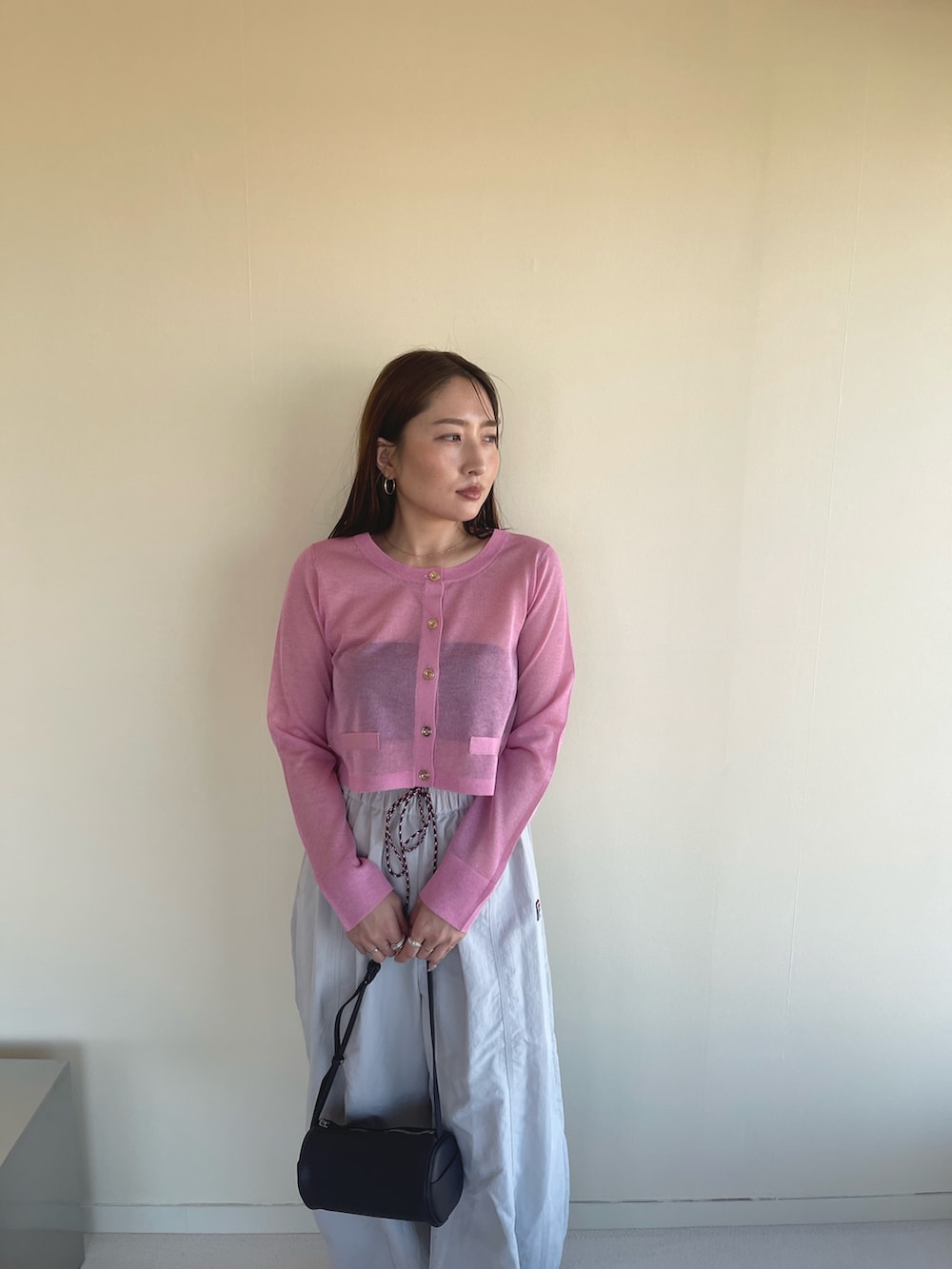 ピンク系のカーディガン/ボレロ、ベージュ系のその他パンツ、ブラック系のパンプスを着用したレディースの冬コーディネートの7枚目の写真