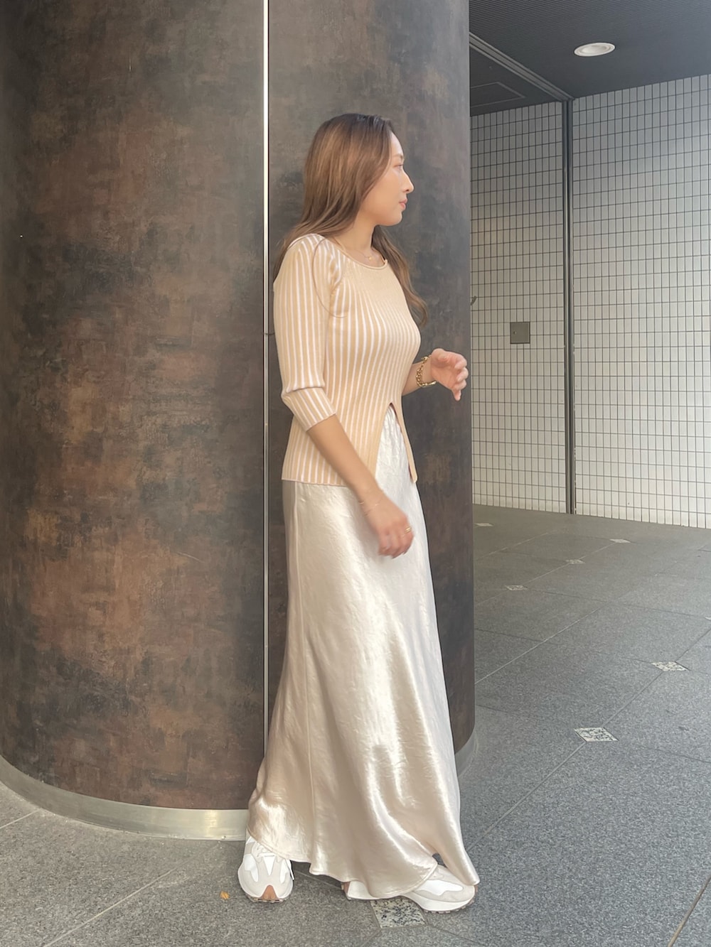 ベージュ系のニット/セーター、ホワイト系のスカートを着用したレディースの冬コーディネートの2枚目の写真