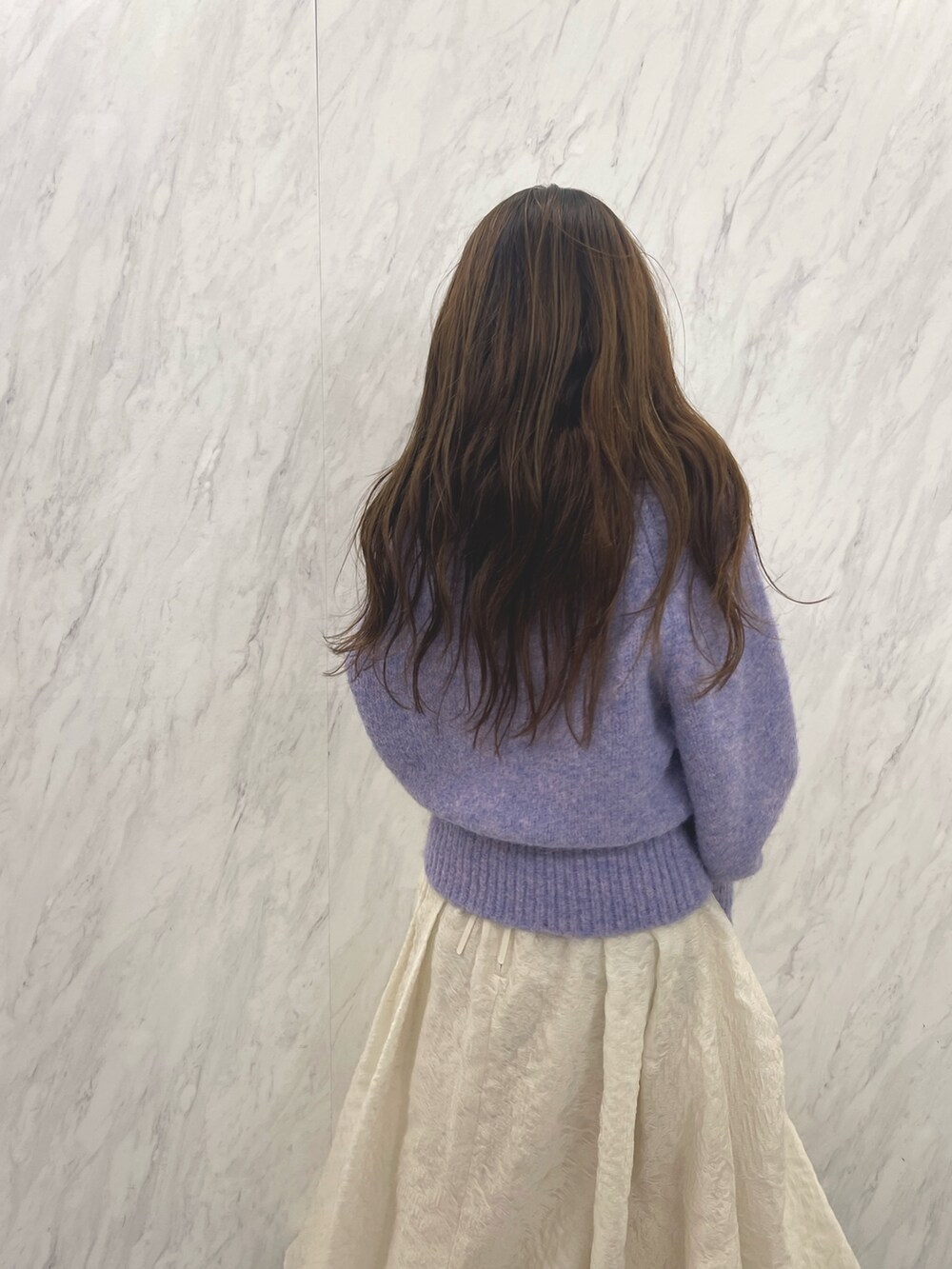 ホワイト系のスカート、ホワイト系のブーツ、パープル系のニット/セーターを着用したレディースの冬コーディネートの7枚目の写真