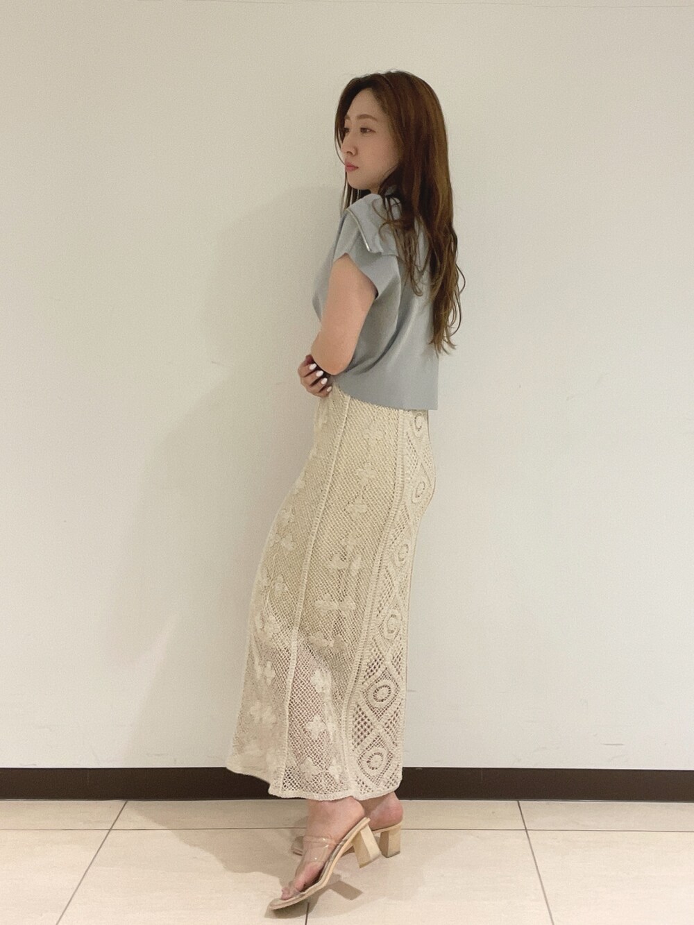 ブルー系のニット/セーター、ホワイト系のスカートを着用したレディースの春コーディネートの5枚目の写真