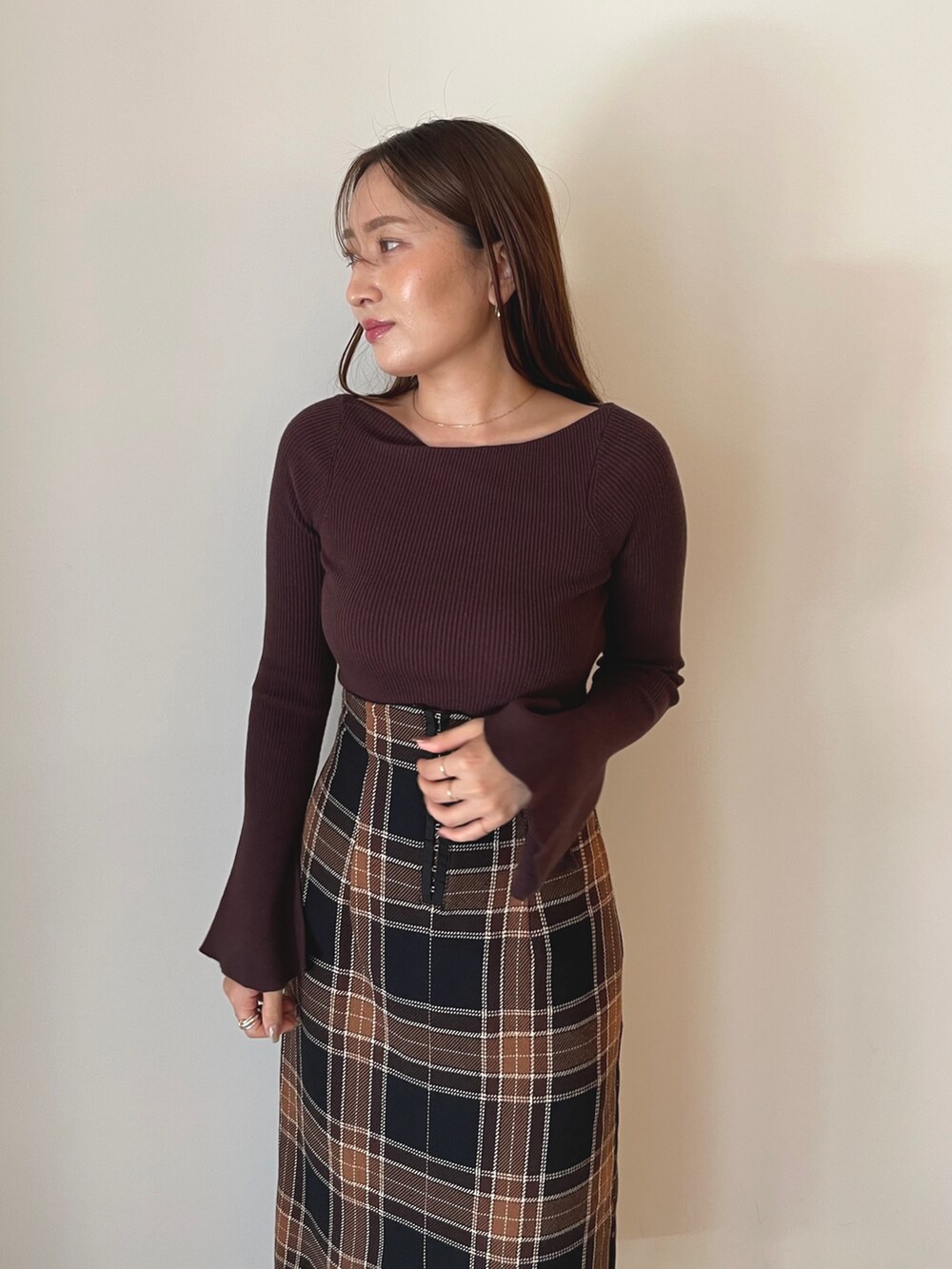 ブラック系のブーツ、ブラウン系のスカート、ブラウン系のニット/セーターを着用したレディースの秋コーディネートの7枚目の写真