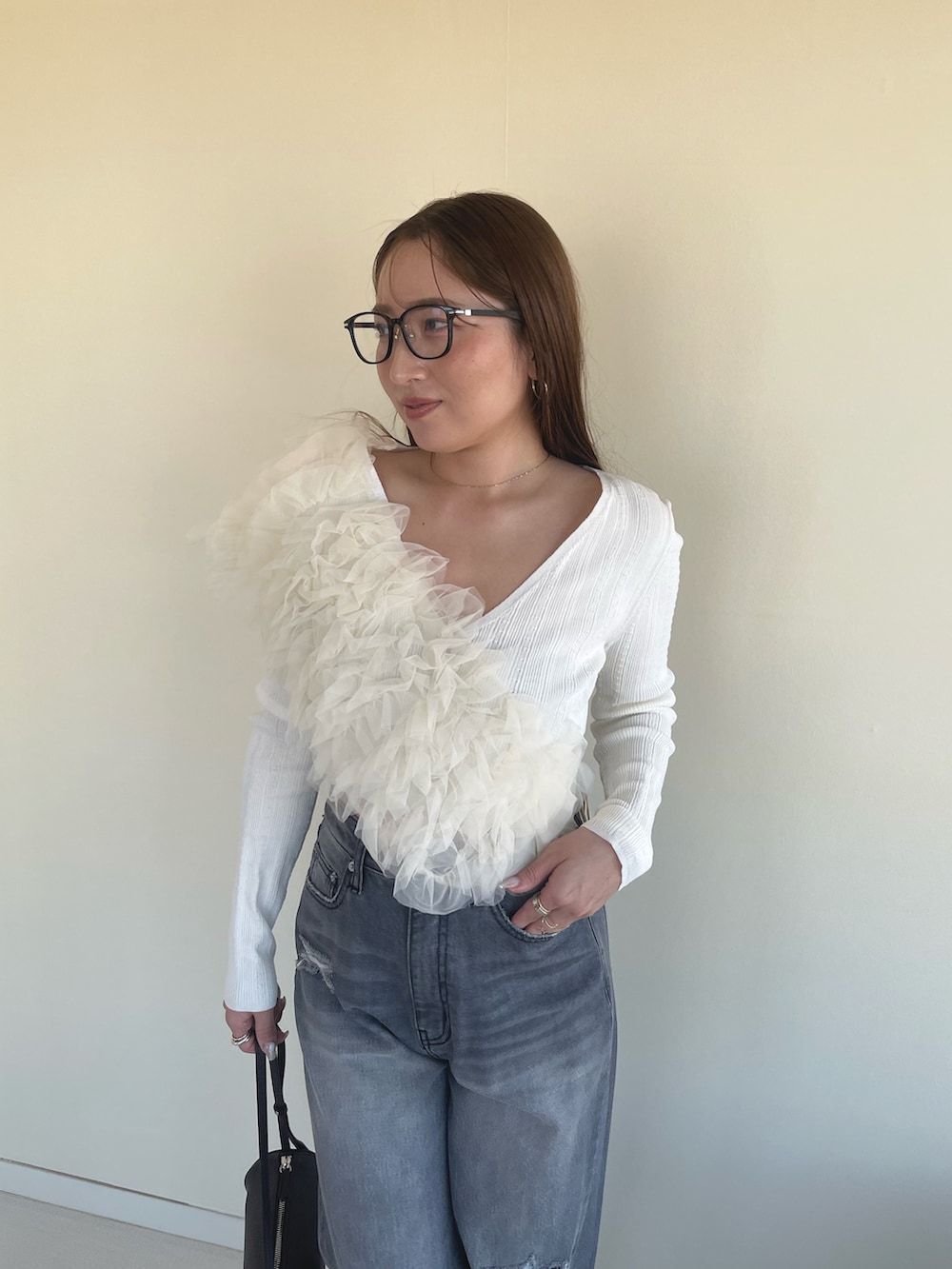 オレンジ系のサンダル、グレー系のデニムパンツ、ホワイト系のカーディガン/ボレロを着用したレディースの春コーディネートの4枚目の写真