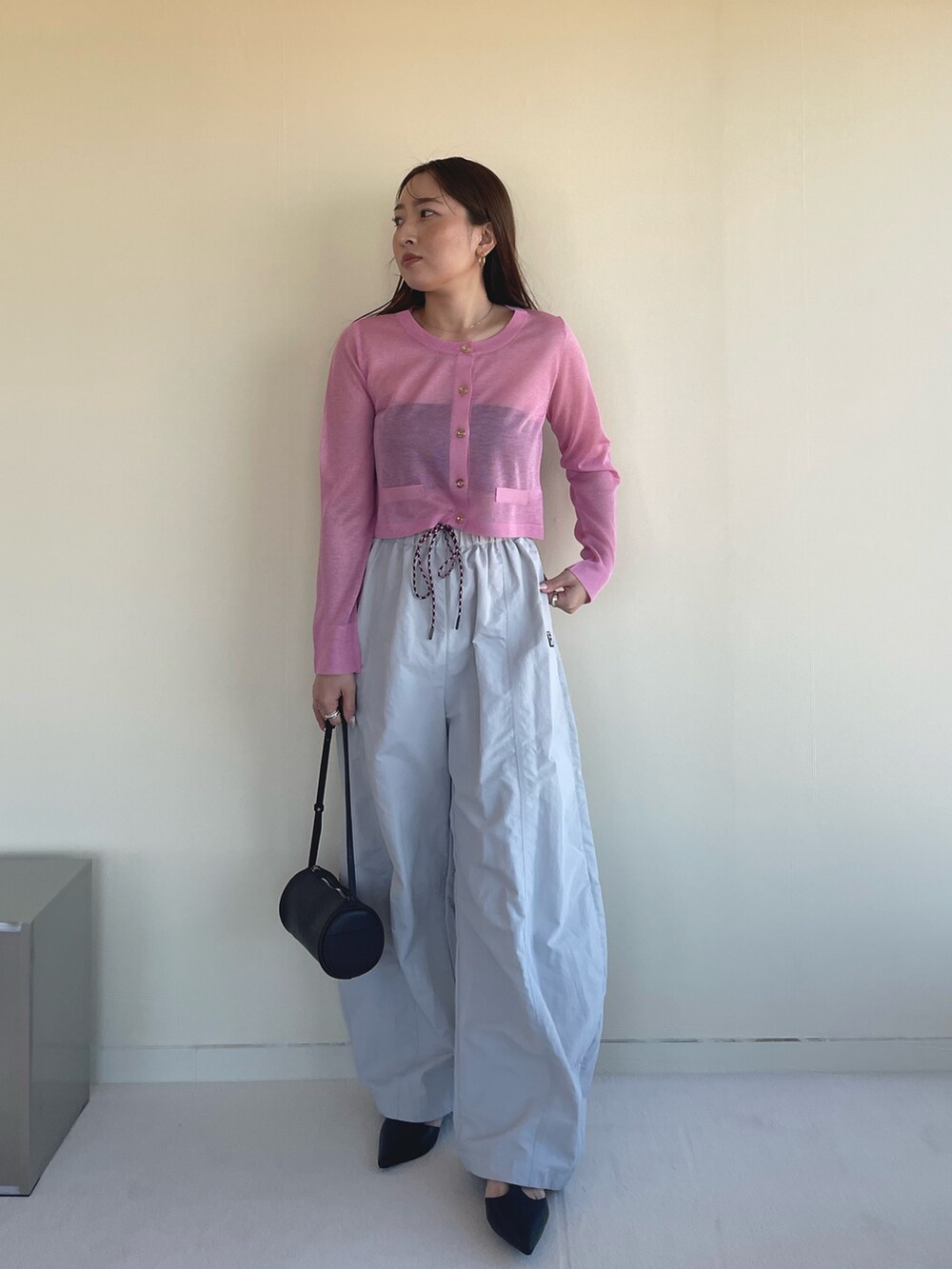 ピンク系のカーディガン/ボレロ、ベージュ系のその他パンツ、ブラック系のパンプスを着用したレディースの冬コーディネートの4枚目の写真