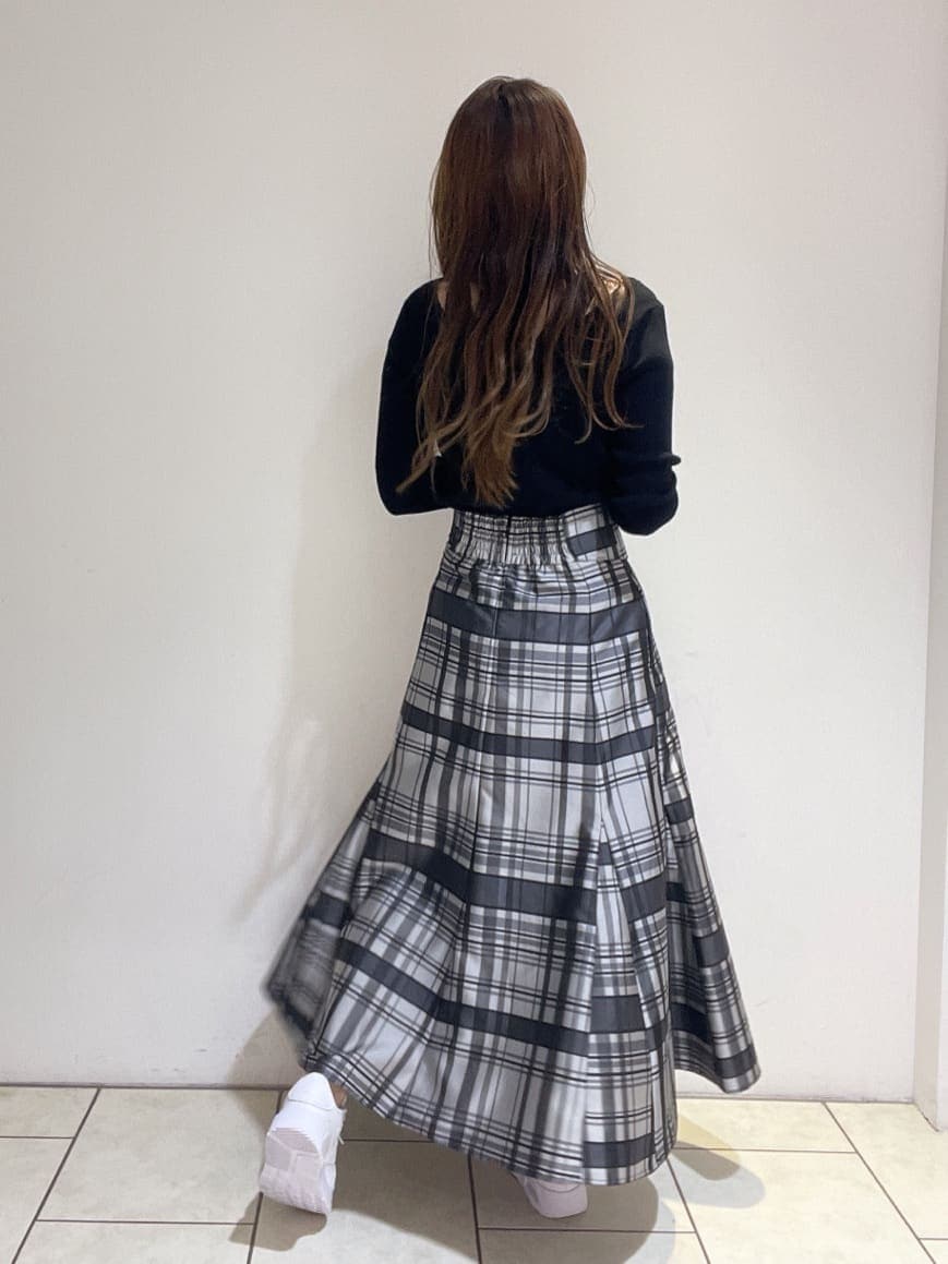 ブラック系のニット/セーター、ホワイト系のスニーカー、ブラック系のスカートを着用したレディースの秋コーディネートの6枚目の写真