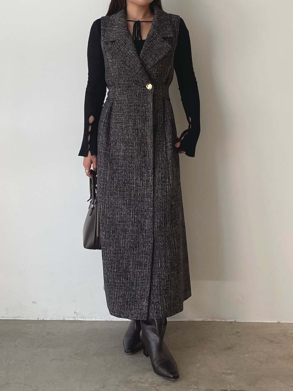 ブラウン系のブーツ、ブラウン系のボストンバッグ、ブラック系のニット/セーターを着用したレディースの秋コーディネートの7枚目の写真