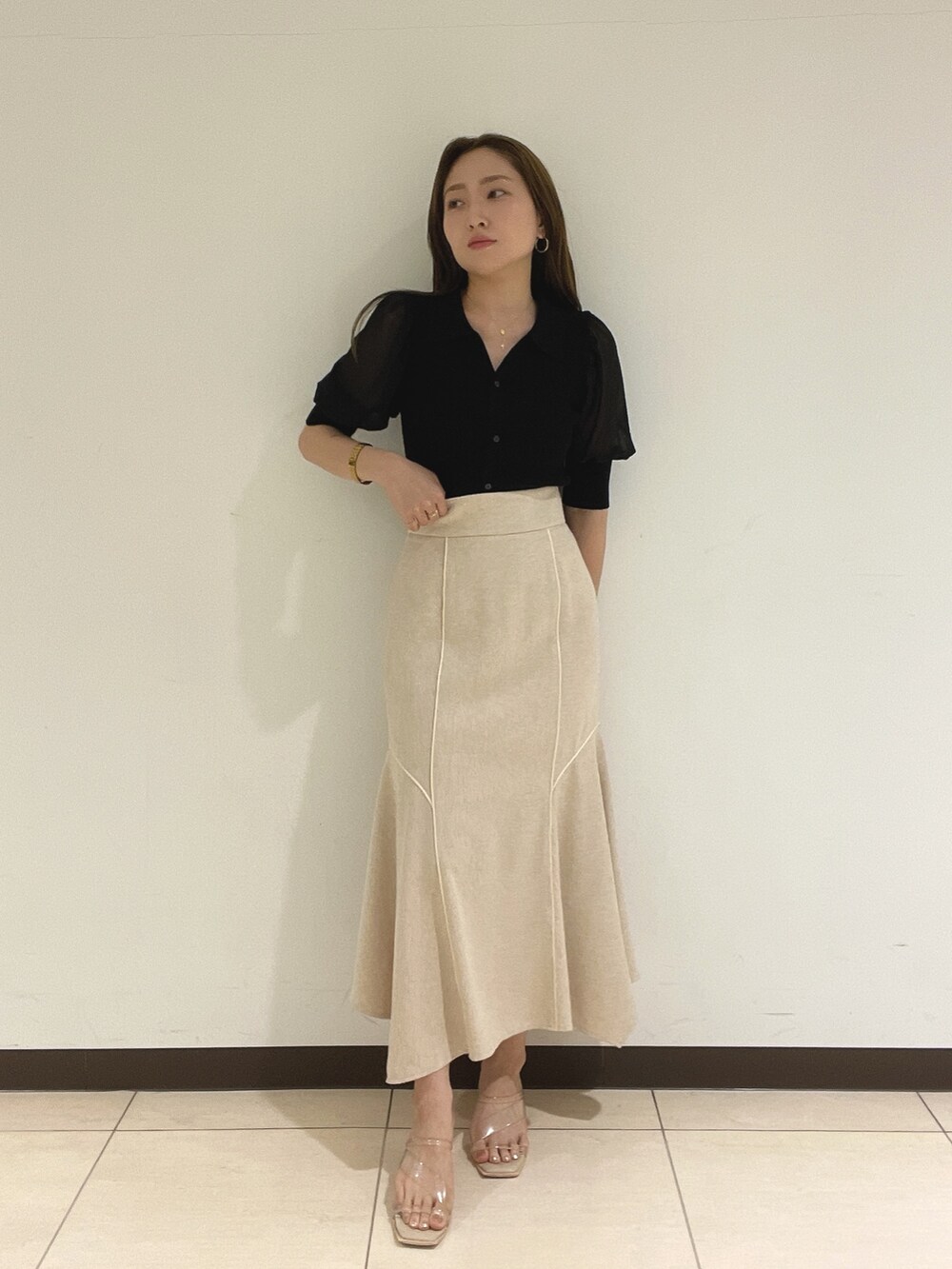 ブラック系のニット/セーター、ホワイト系のスカートを着用したレディースの夏コーディネートの4枚目の写真