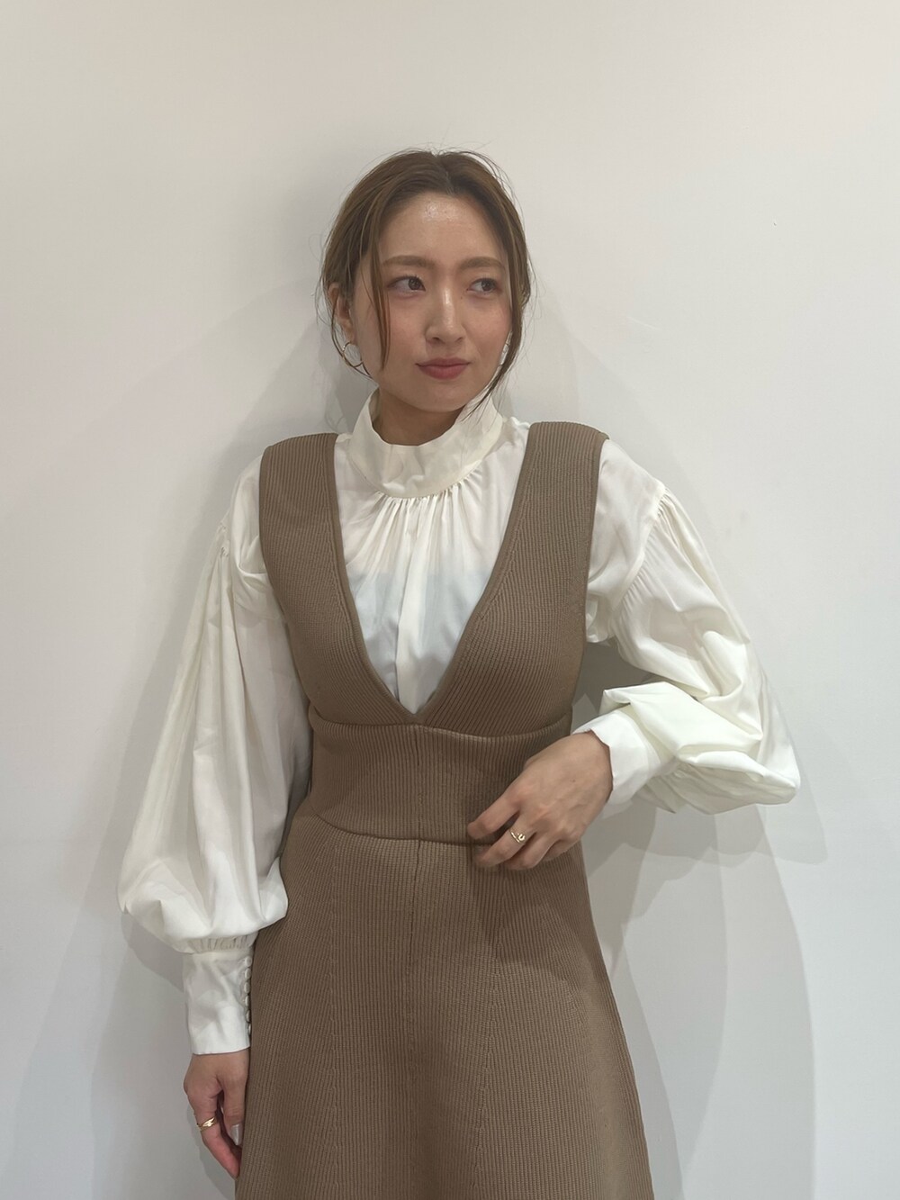 ブラック系のブーツ、ベージュ系のジャンパースカート、ホワイト系のシャツ/ブラウスを着用したレディースの秋コーディネートの5枚目の写真