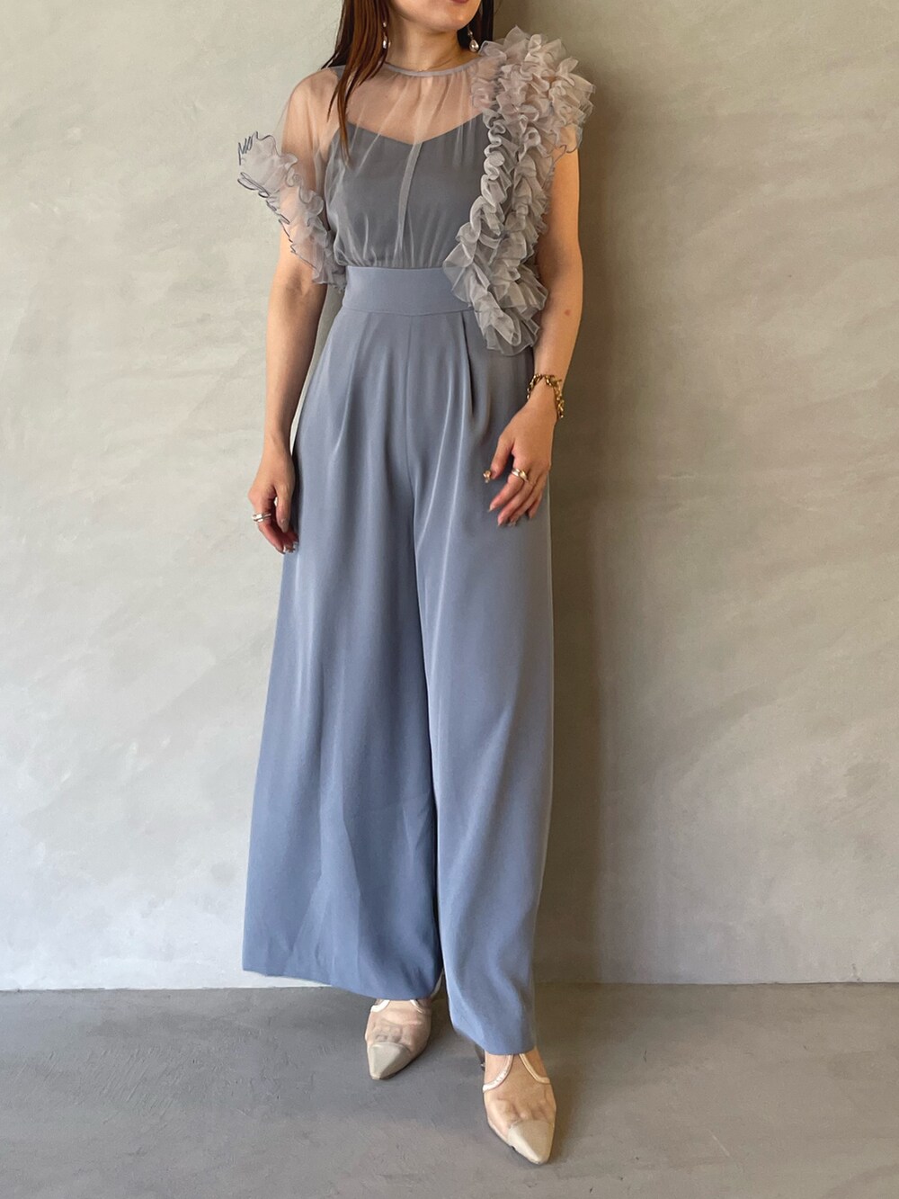 ブルー系のパンツドレス、ゴールド系のピアス（両耳用）を着用したレディースの夏コーディネートの2枚目の写真