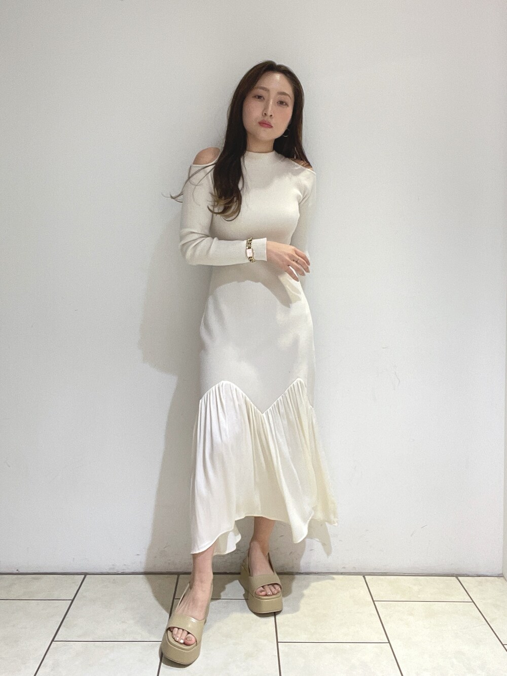 ホワイト系のワンピース、ベージュ系のサンダルを着用したレディースの冬コーディネートの2枚目の写真