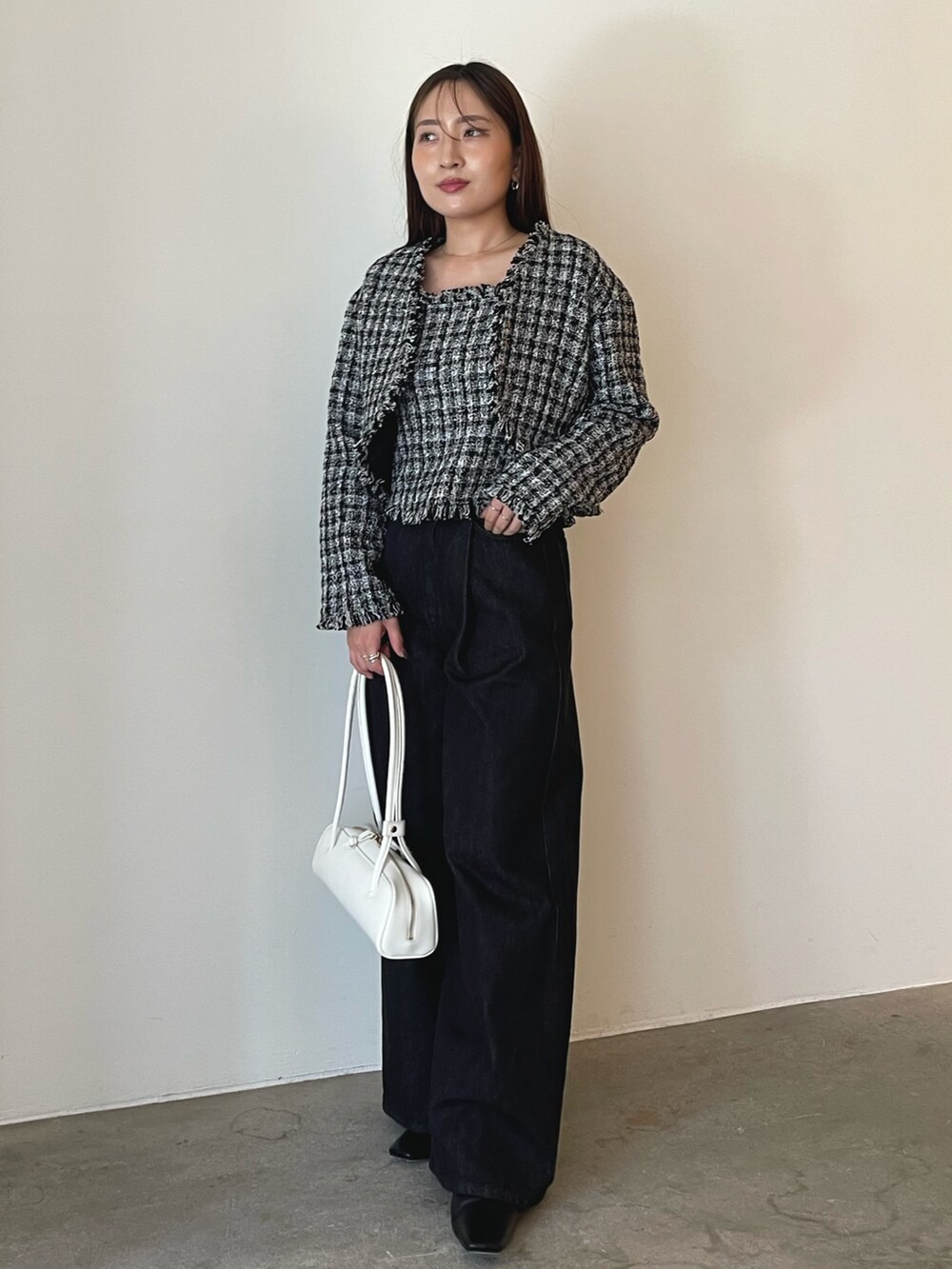 ホワイト系のショルダーバッグ、ブラック系のキャミソール、ブラック系のテーラードジャケットを着用したレディースの秋コーディネートの2枚目の写真