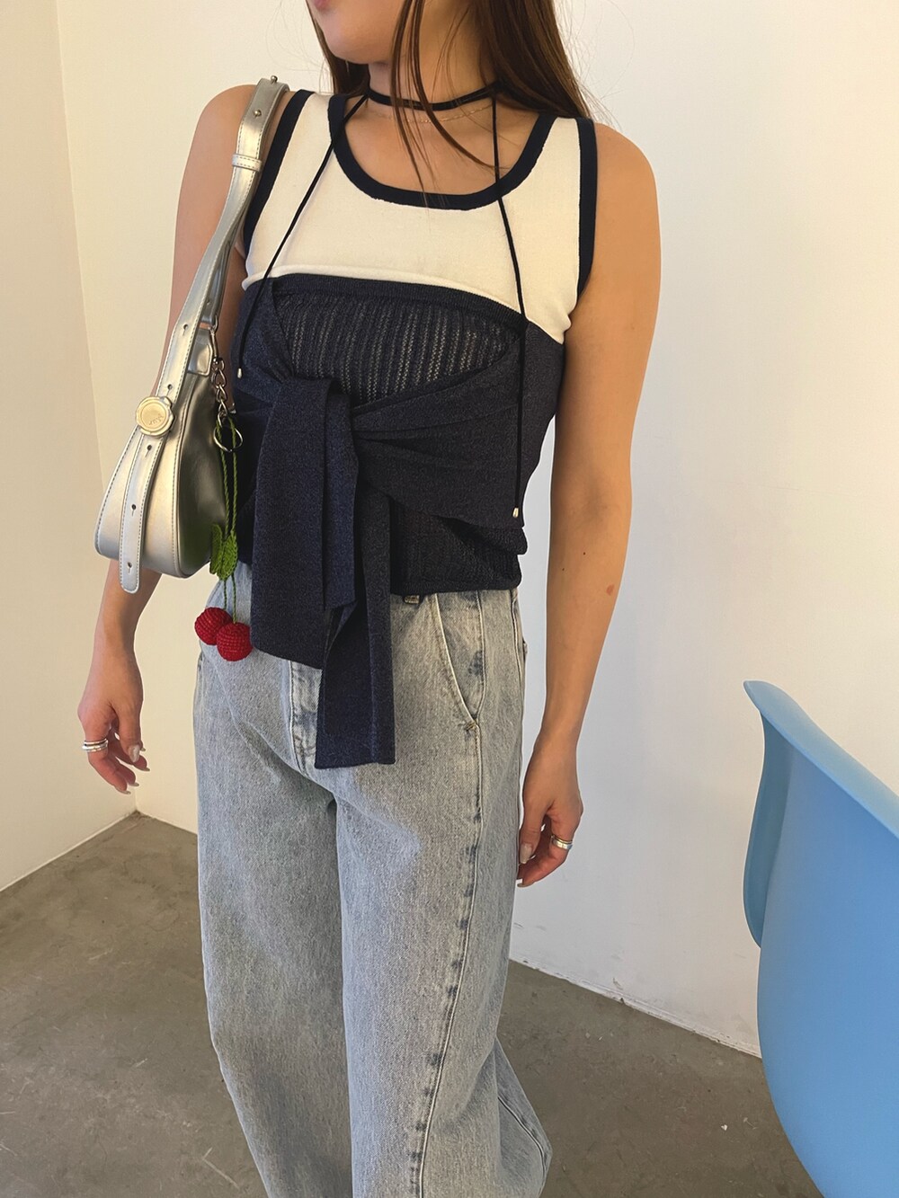 ブルー系のデニムパンツ、シルバー系のハンドバッグ、ブラウン系のサンダルを着用したレディースの春コーディネートの9枚目の写真