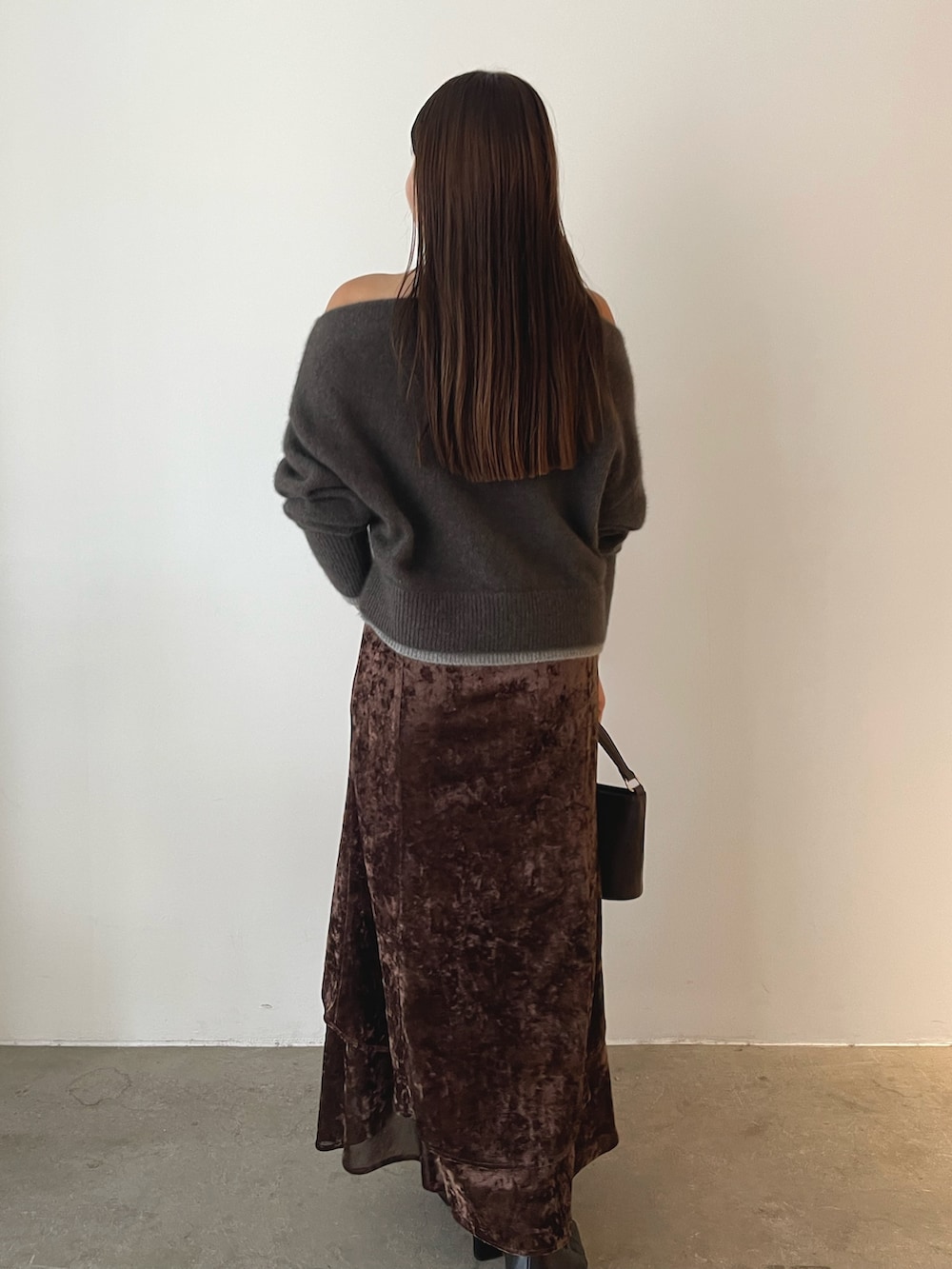 ブラウン系のハンドバッグ、ブラウン系のニット/セーター、ブラウン系のスカートを着用したレディースの秋コーディネートの5枚目の写真