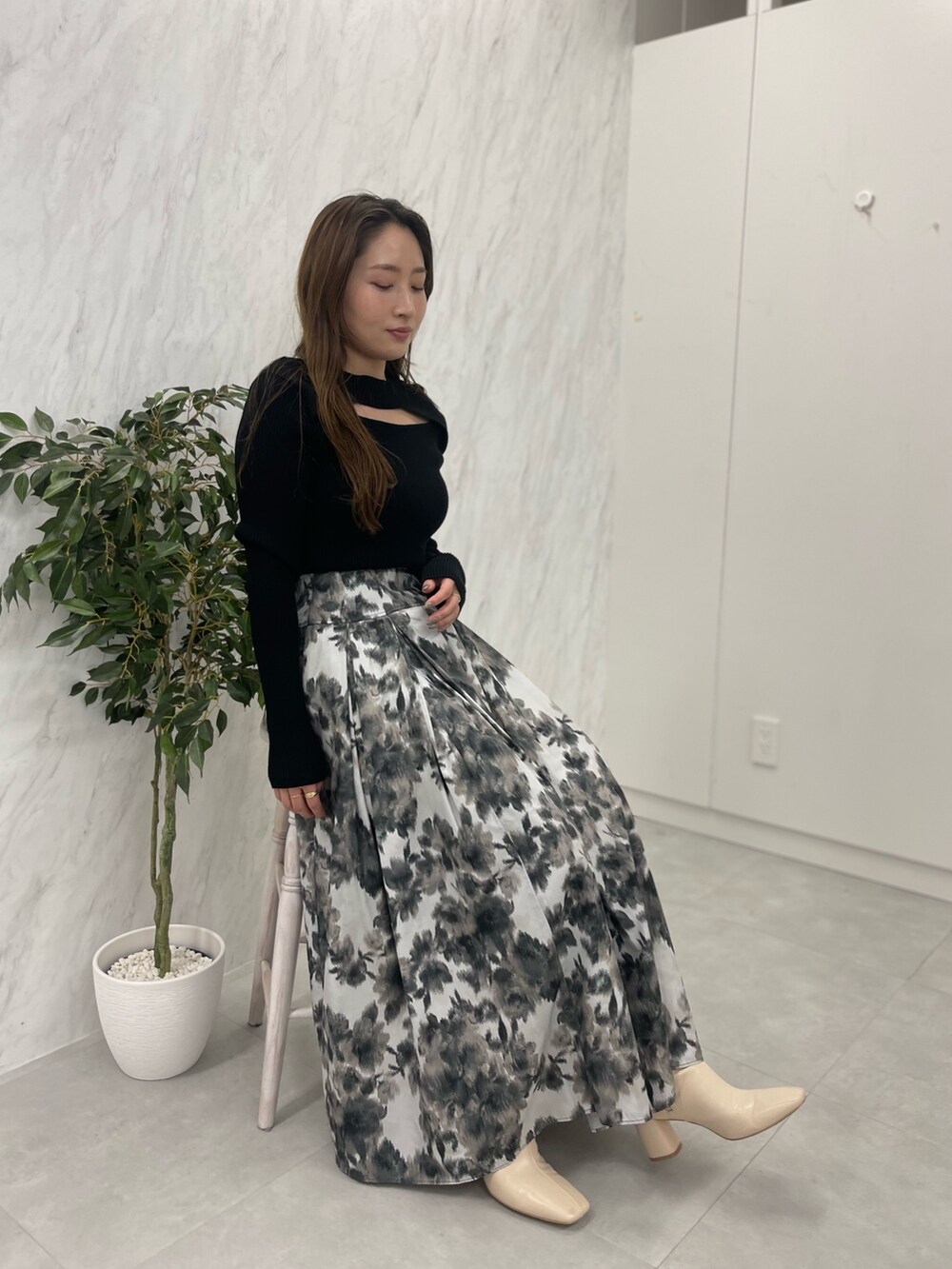 ホワイト系のブーツ、ブラック系のニット/セーター、グリーン系のハンドバッグを着用したレディースの冬コーディネートの7枚目の写真