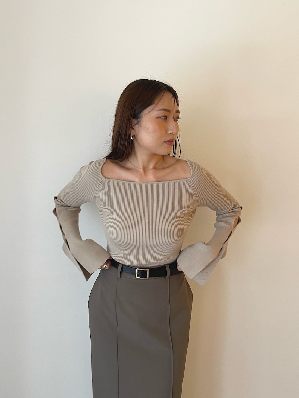 ブラック系のパンプス、グレー系のスカート、ベージュ系のニット/セーターを着用したレディースの秋コーディネートの10枚目の写真