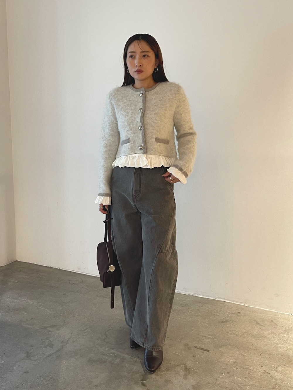 ブラウン系のハンドバッグ、グレー系のデニムパンツ、グレー系のノーカラージャケットを着用したレディースの秋コーディネートの7枚目の写真