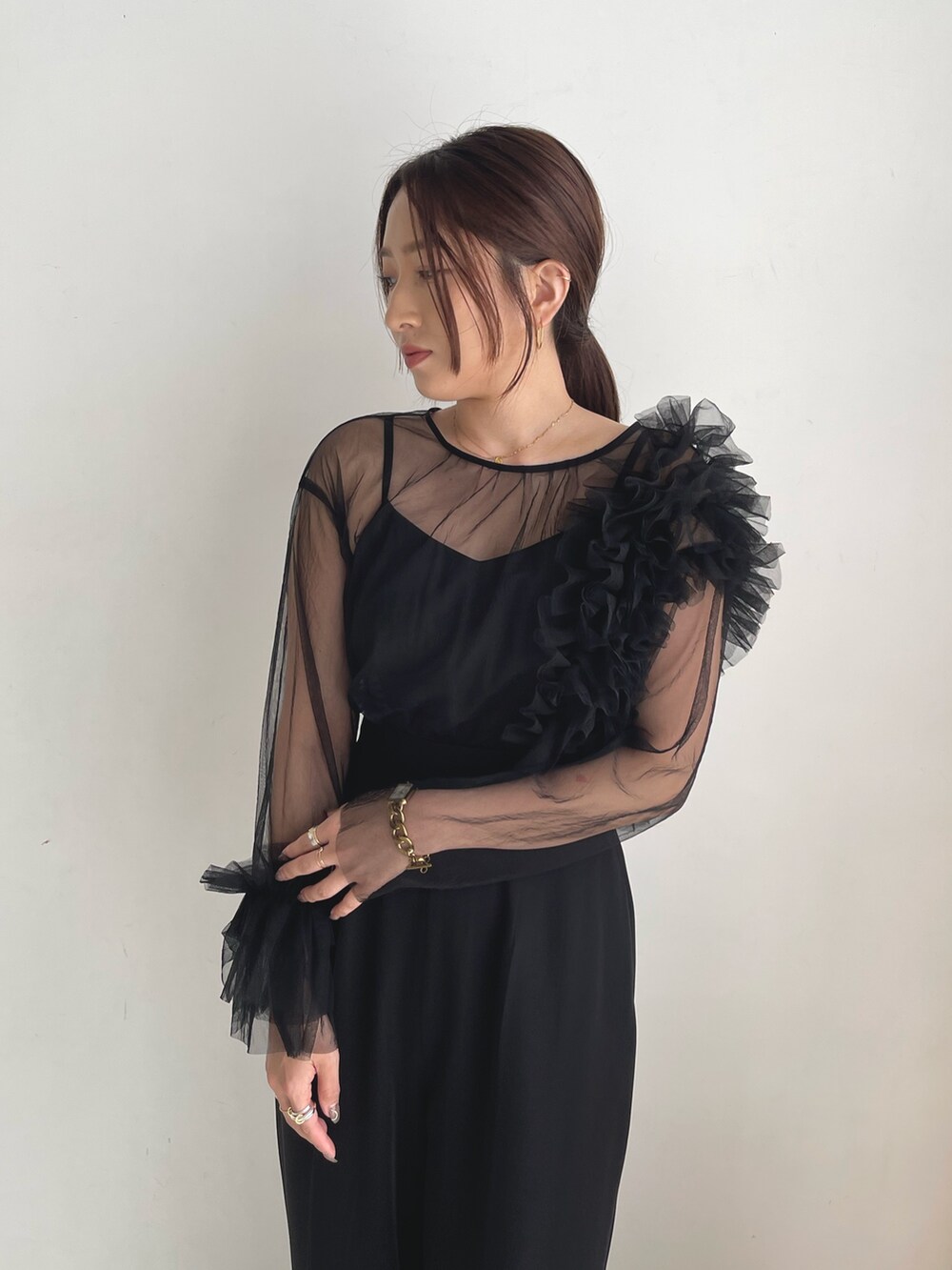 ブラック系のパンツドレス、シルバー系のパンプスを着用したレディースの秋コーディネートの9枚目の写真