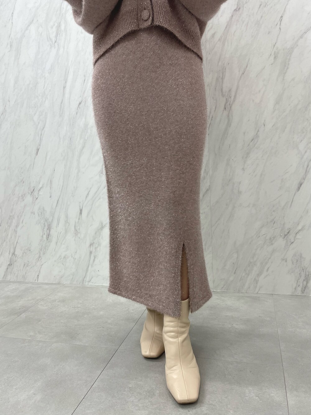 ピンク系のカーディガン/ボレロ、ピンク系のスカート、ホワイト系のブーツを着用したレディースの冬コーディネートの8枚目の写真