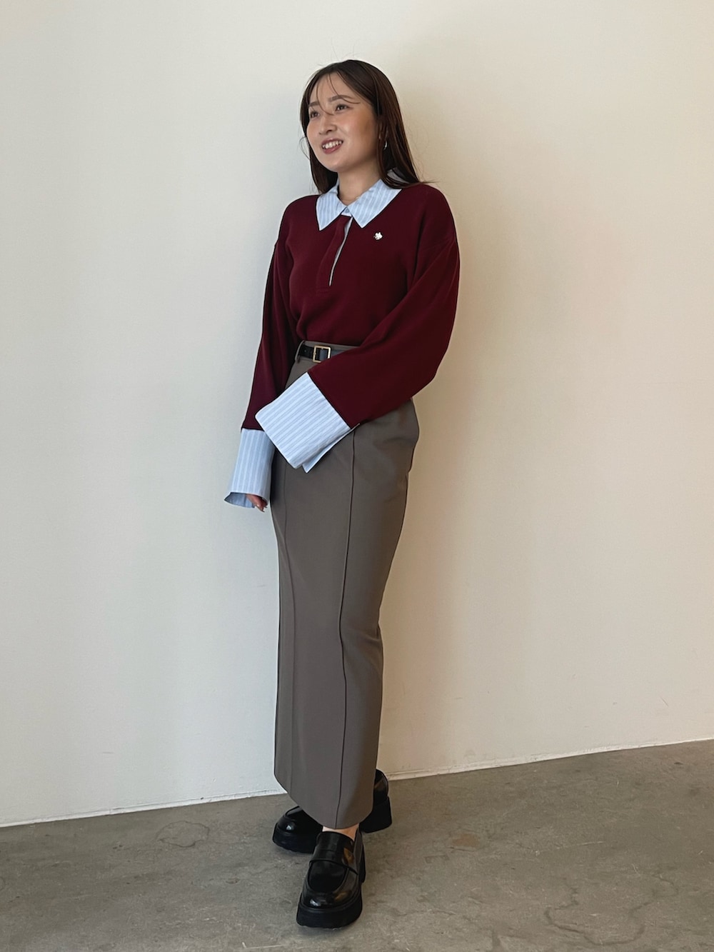 グレー系のスカート、レッド系のニット/セーターを着用したレディースの夏コーディネートの2枚目の写真