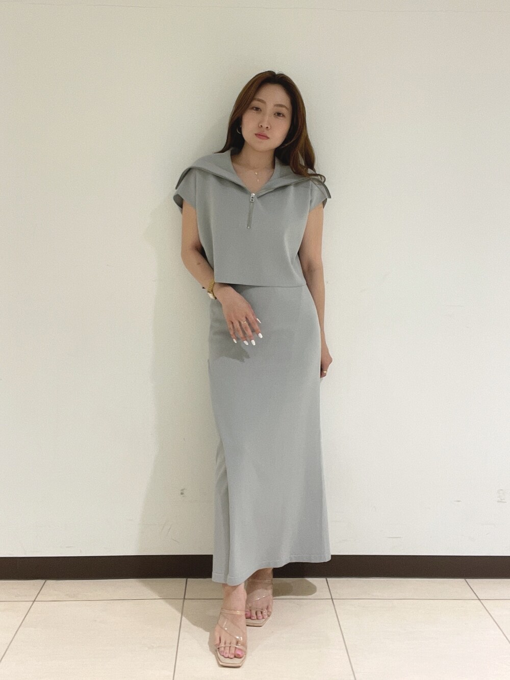 ブルー系のニット/セーター、ブルー系のスカートを着用したレディースの春コーディネートの2枚目の写真