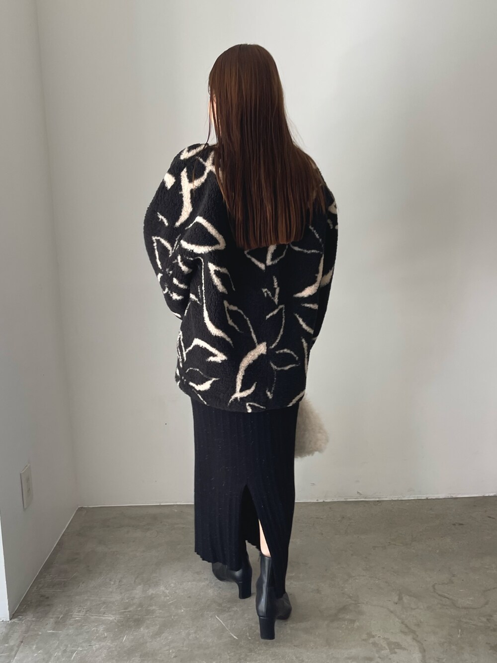 ブラック系のブーツ、ホワイト系のボストンバッグ、ブラック系のブルゾンを着用したレディースの秋コーディネートの5枚目の写真