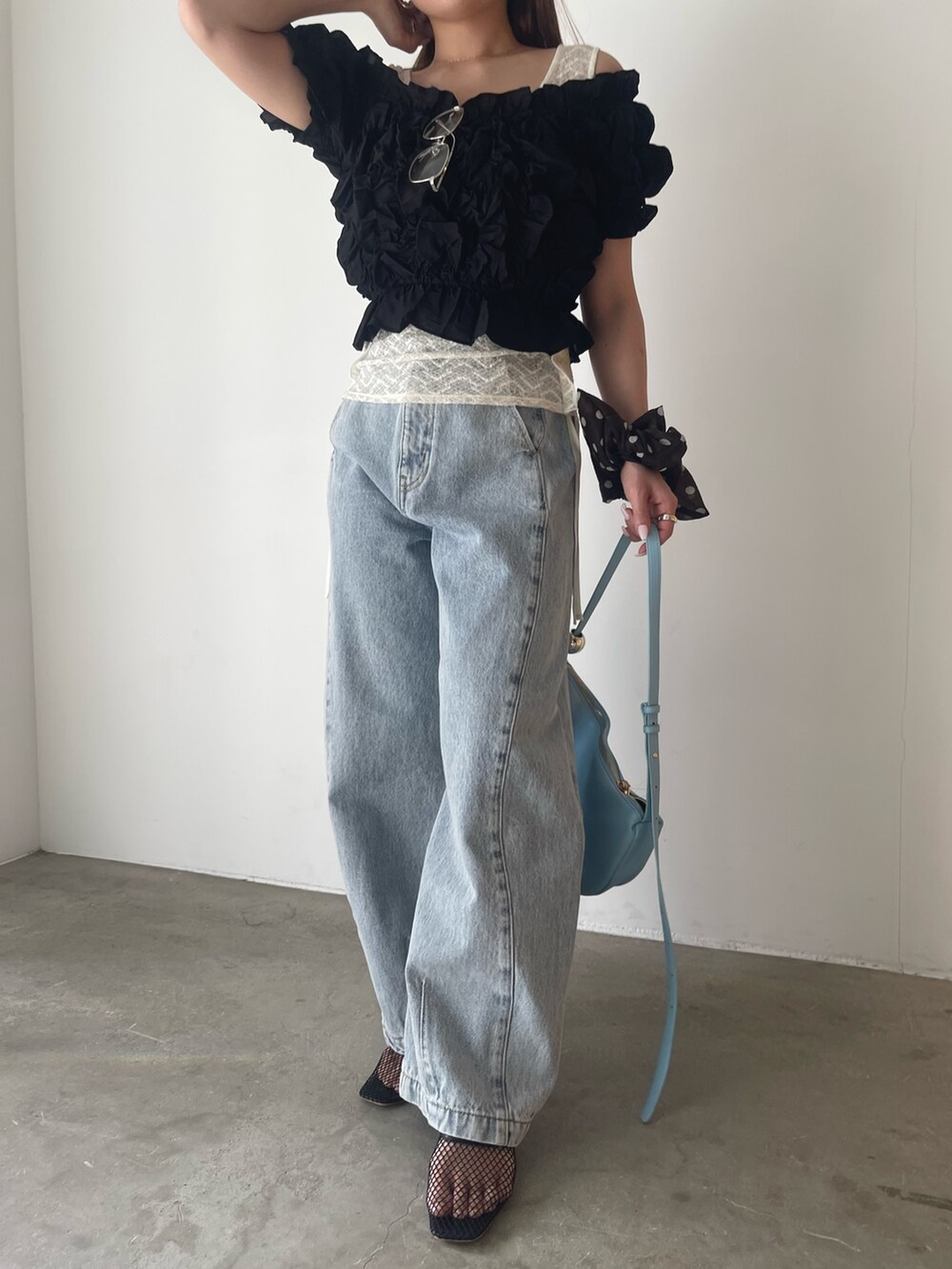 ブラック系のパンツドレス、ブルー系のデニムパンツ、ホワイト系のシャツ/ブラウスを着用したレディースの春コーディネートの8枚目の写真