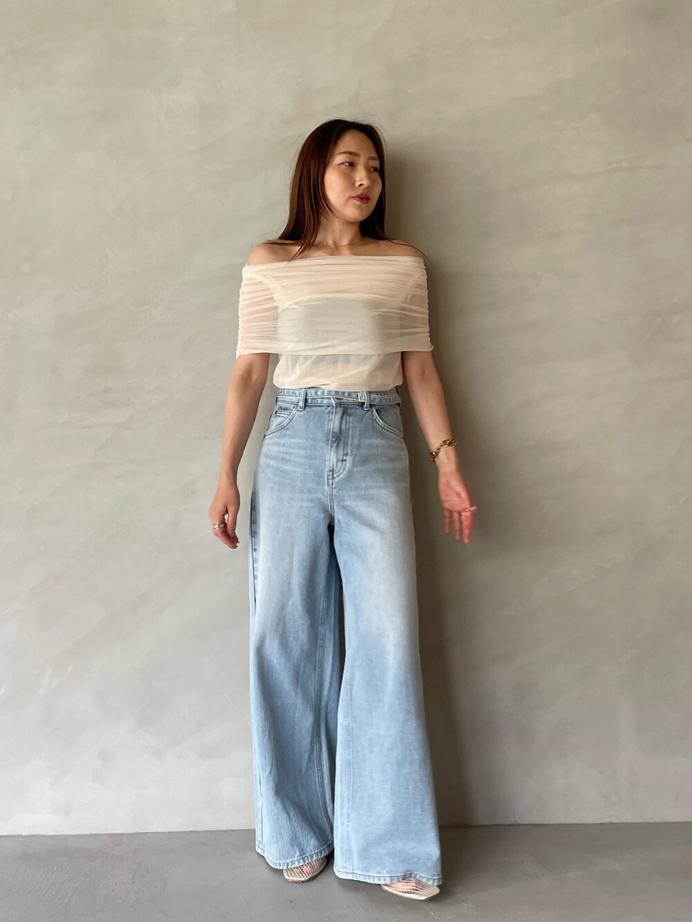 ブルー系のデニムパンツ、ホワイト系のTシャツ/カットソー、ホワイト系のサンダルを着用したレディースの夏コーディネートの2枚目の写真