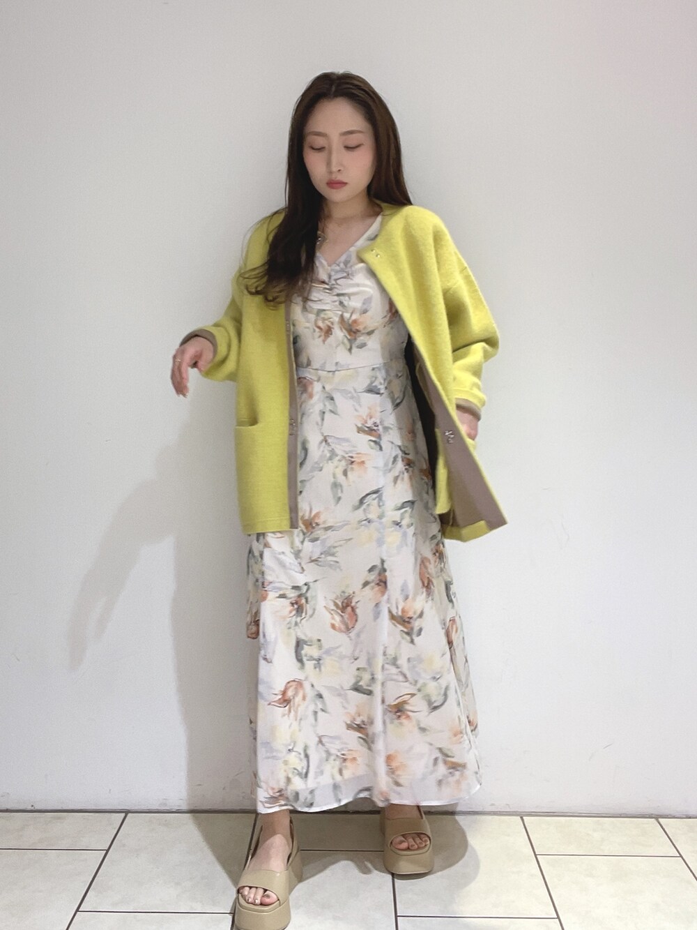 ホワイト系のワンピース、イエロー系のカーディガン/ボレロ、ベージュ系のサンダルを着用したレディースの冬コーディネートの4枚目の写真