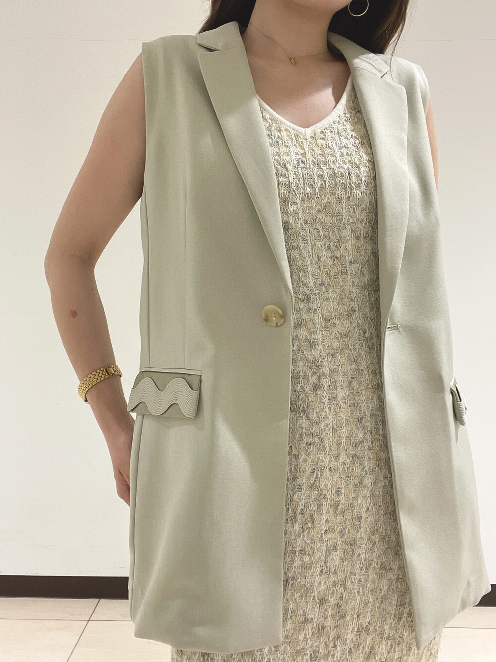 ホワイト系のワンピース、ベージュ系のベストを着用したレディースの春コーディネートの10枚目の写真