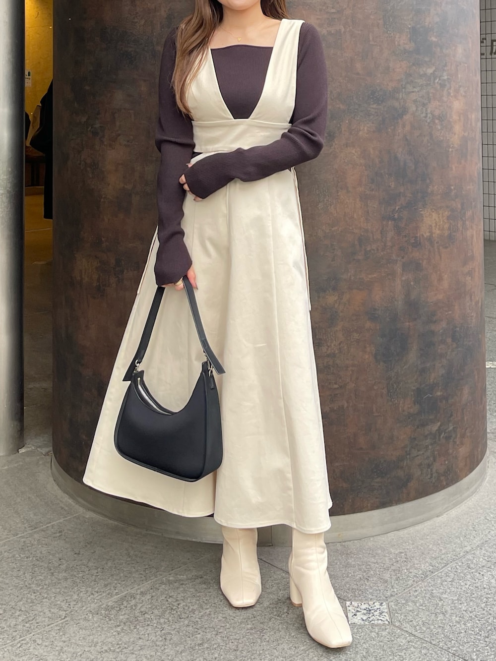 ホワイト系のブーツ、ホワイト系のジャンパースカート、ブラック系のニット/セーターを着用したレディースの冬コーディネートの4枚目の写真