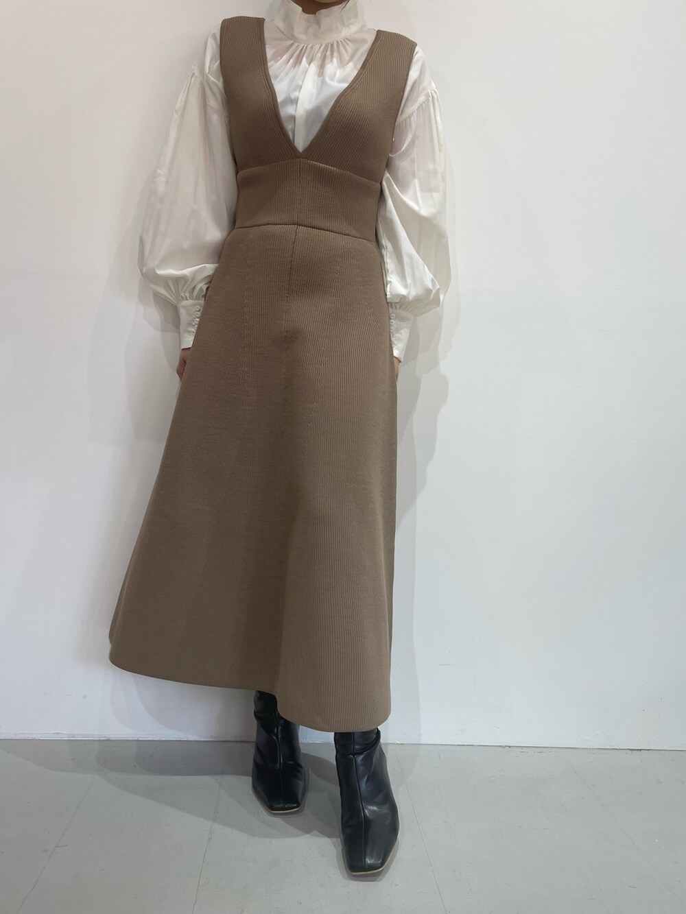 ベージュ系のジャンパースカート、ホワイト系のシャツ/ブラウス、ブラック系のブーツを着用したレディースの秋コーディネートの7枚目の写真