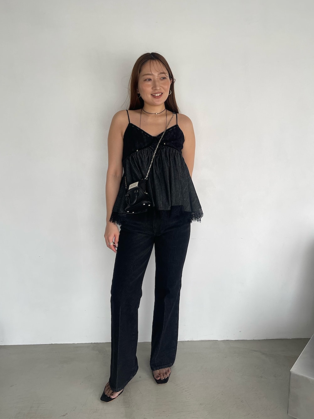 ブラック系のデニムパンツ、ブラック系のキャミソールを着用したレディースの夏コーディネートの2枚目の写真