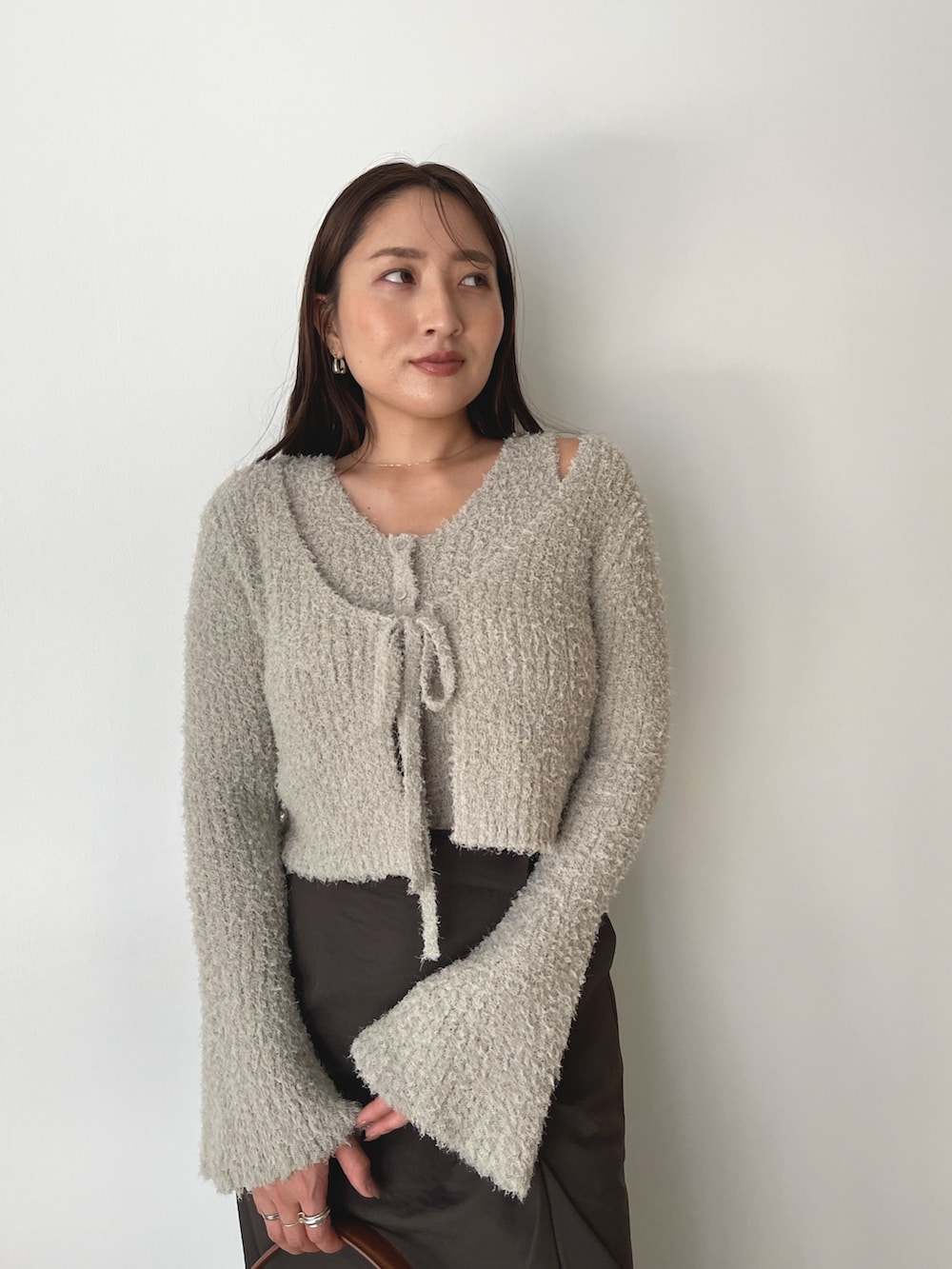 グレー系のアンサンブル、イエロー系のハンドバッグ、ブラウン系のスカートを着用したレディースの秋コーディネートの8枚目の写真