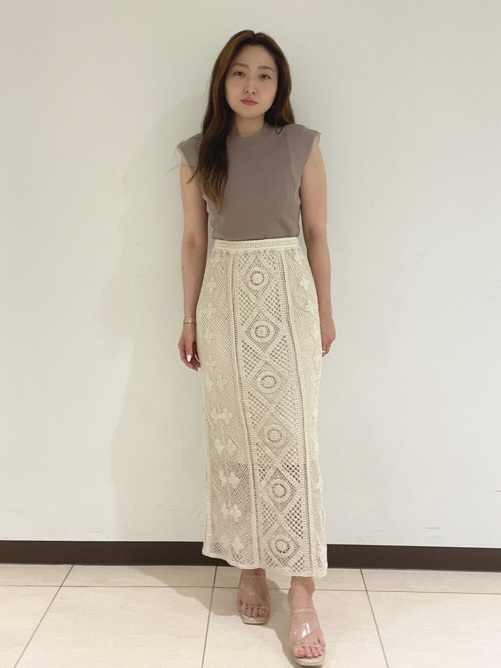 ホワイト系のスカート、ベージュ系のニット/セーターを着用したレディースの夏コーディネートの9枚目の写真