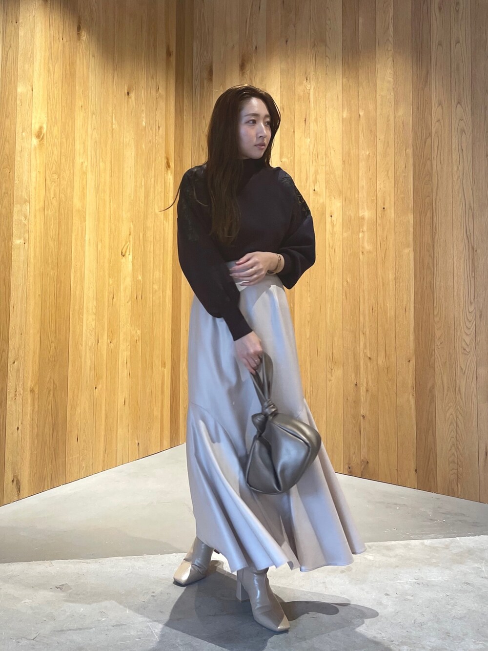 グレー系のニット/セーター、その他のハンドバッグ、ブラウン系のスカートを着用したレディースの秋コーディネートの3枚目の写真