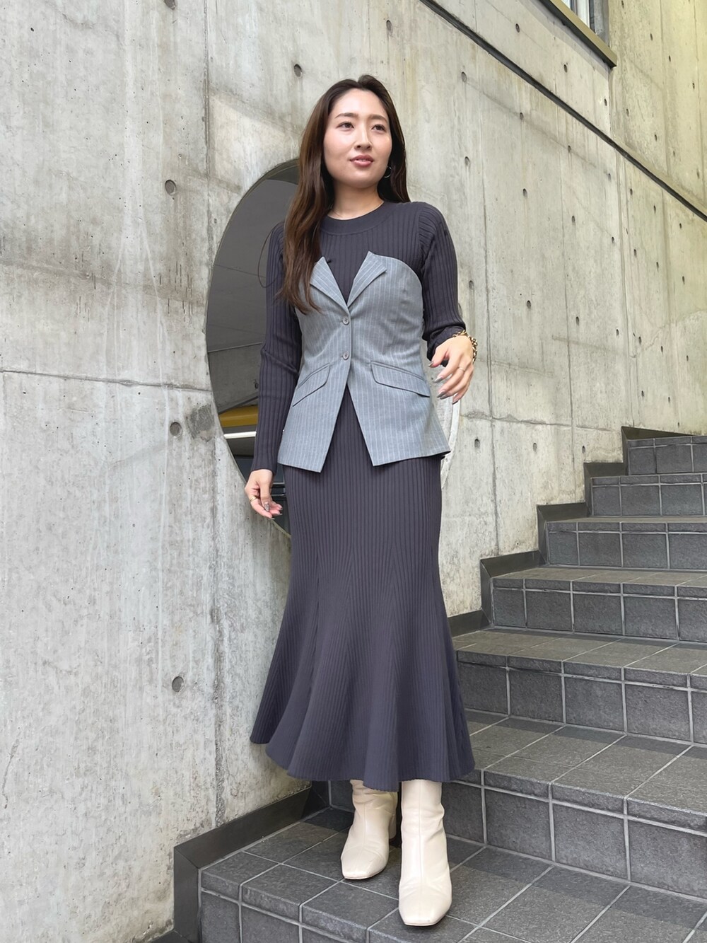 グレー系のワンピース、ホワイト系のブーツを着用したレディースの冬コーディネートの3枚目の写真