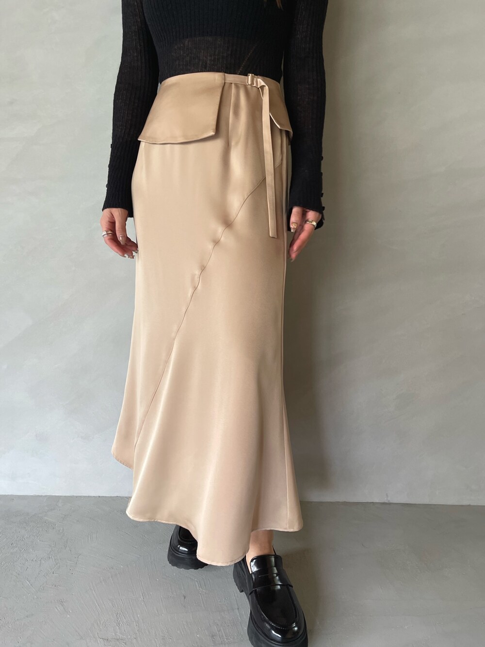 ベージュ系のスカート、ブラック系のニット/セーターを着用したレディースの夏コーディネートの8枚目の写真