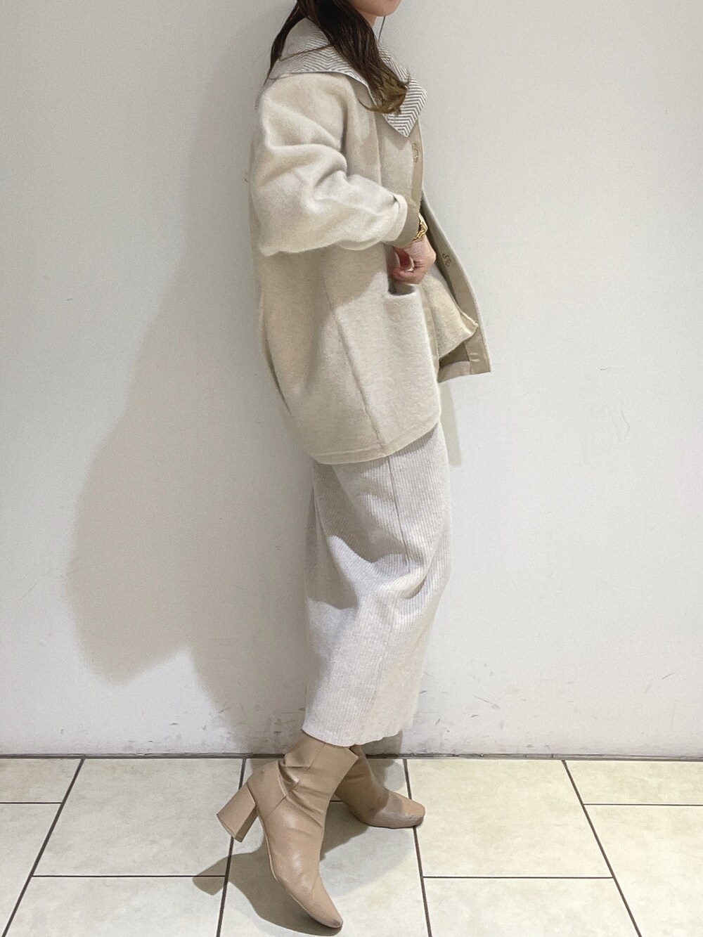 ホワイト系のワンピース、ホワイト系のカーディガン/ボレロ、ベージュ系のブーツを着用したレディースの冬コーディネートの6枚目の写真