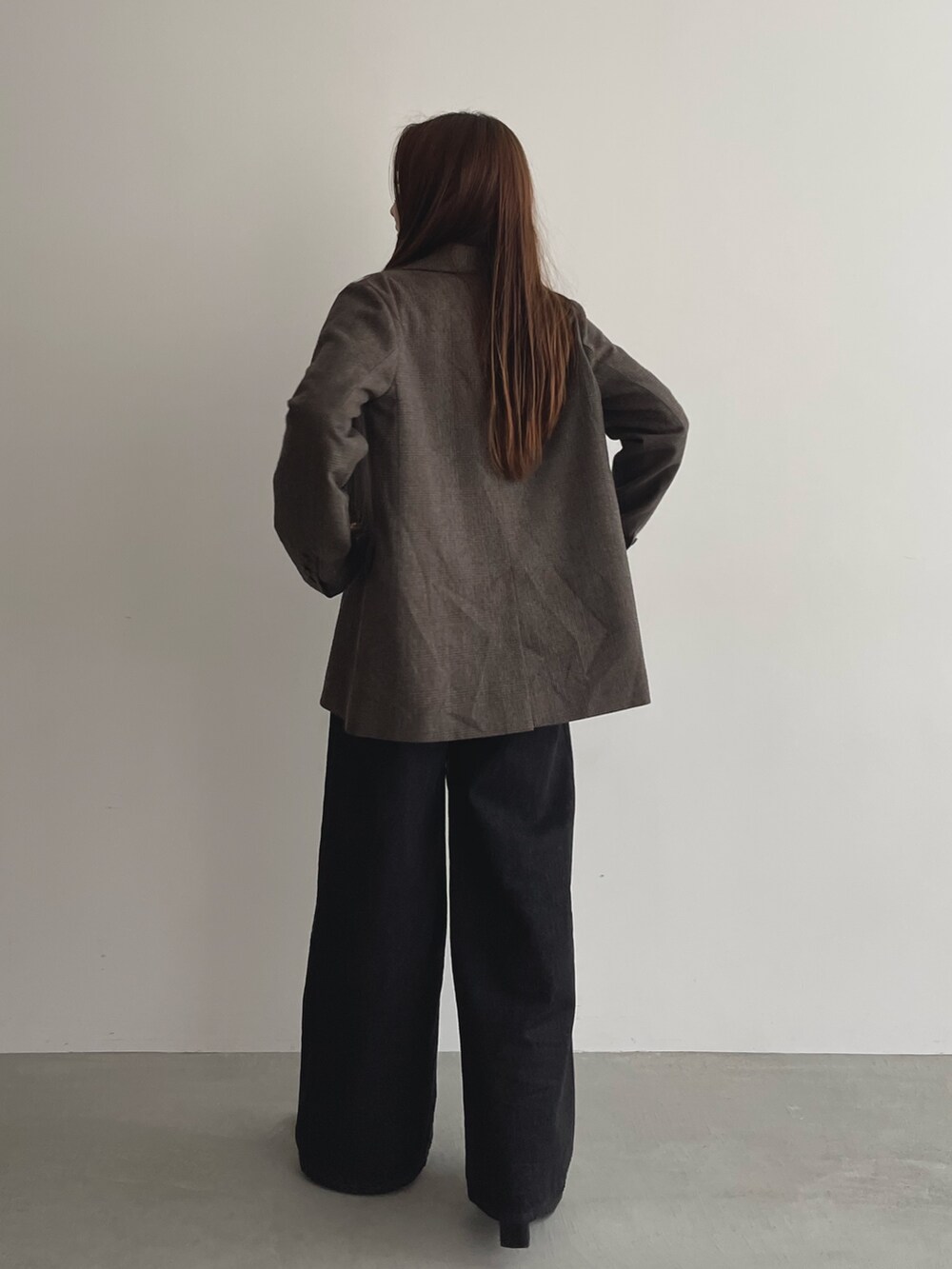 ブラック系のデニムパンツ、グレー系のニット/セーター、ブラウン系のテーラードジャケットを着用したレディースの夏コーディネートの6枚目の写真