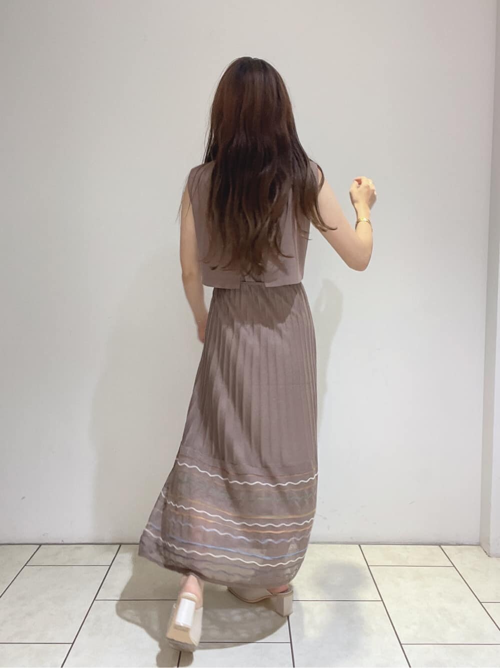 ホワイト系のサンダル、ブラウン系のワンピースを着用したレディースの夏コーディネートの5枚目の写真